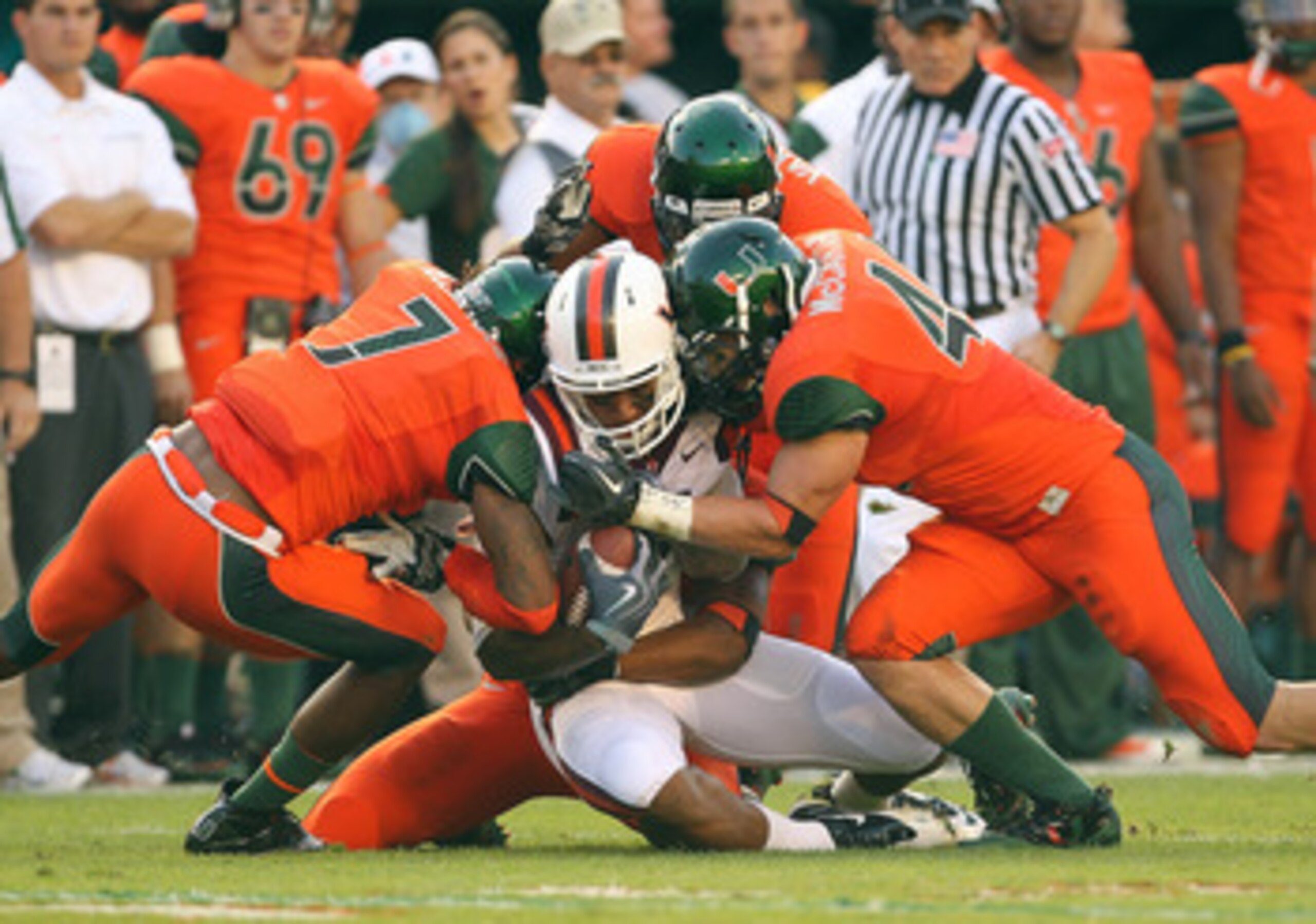 MIAMI - NOVEMBER 20:  Marcus Davis #7 of the Virginia Tech Hokies is hit by Vaughn Telemaque #7 and Colin McCarthy #44 of the Miami Hurricanes at Sun Life Stadium on November 20, 2010 in Miami, Florida.  (Photo by Mike Ehrmann/Getty Images)