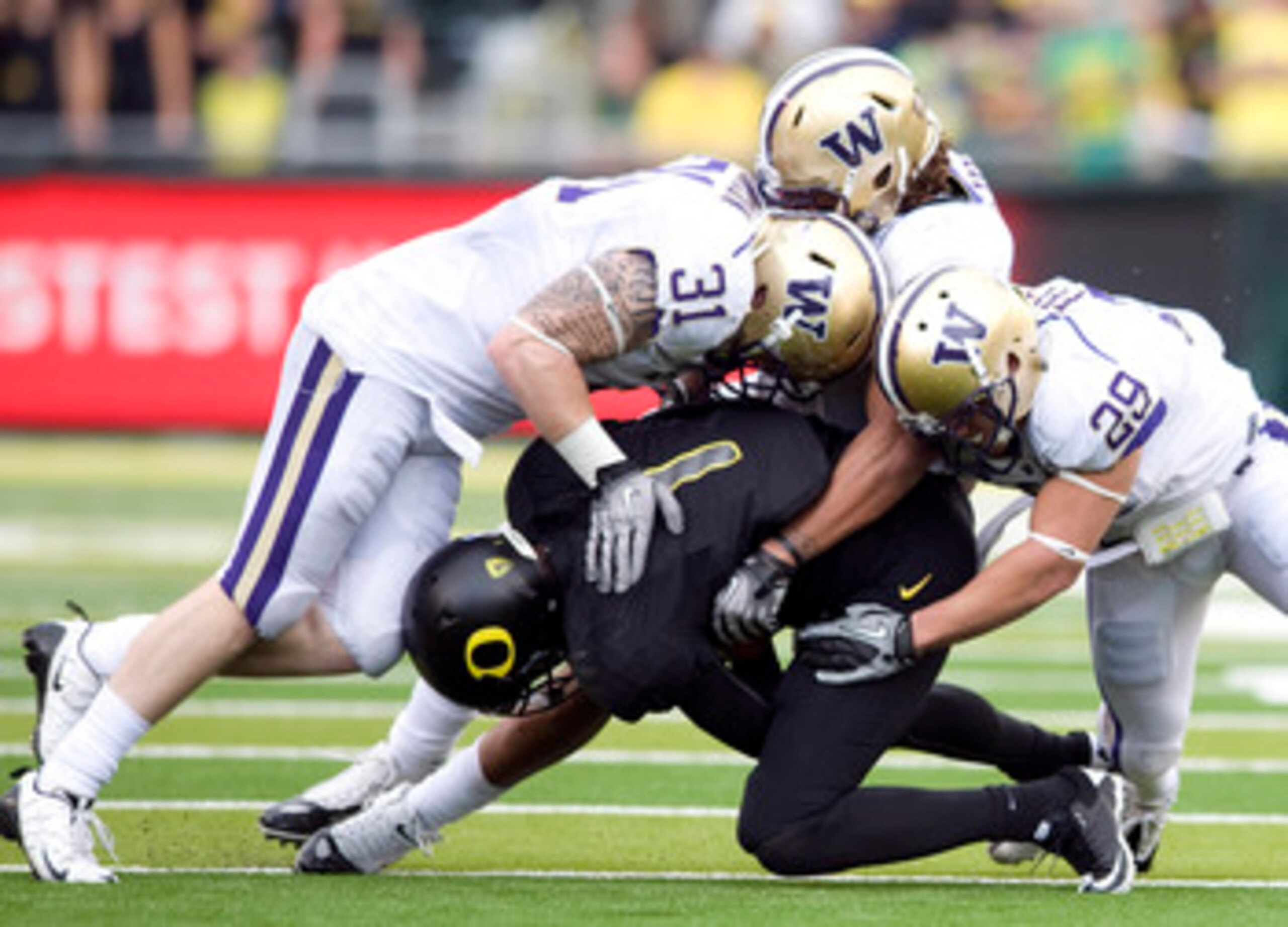 EUGENE, OR - NOVEMBER 6: Quarterback Darron Thomas #1 of the Oregon Ducks is tackled by linebacker Cort Dennison #31 and safety Nate Fellner #29 of the Washington Huskies in the third quarter of the game at Autzen Stadium on November 6, 2010 in Eugene, Or