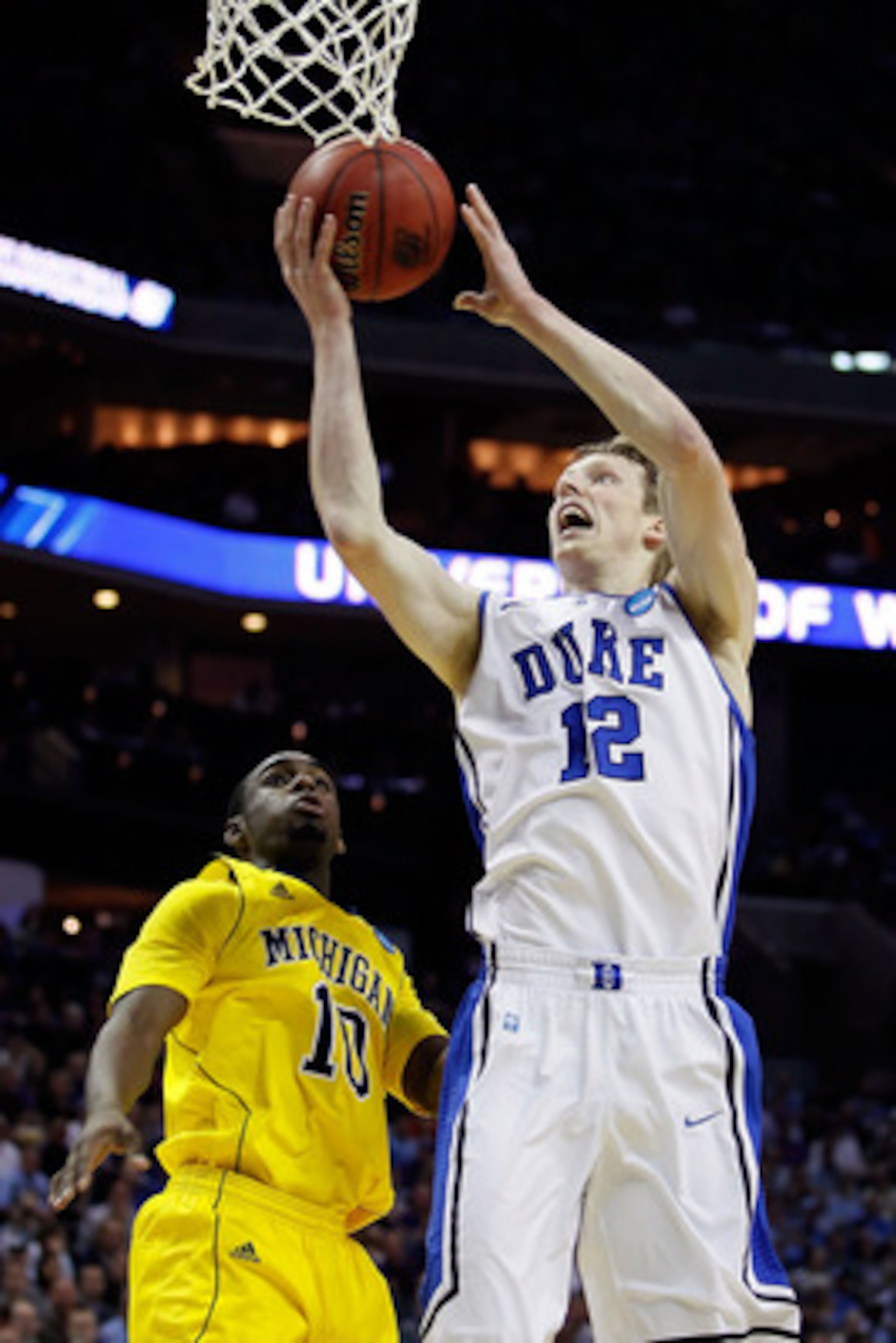 CHARLOTTE, NC - MARCH 20:  Kyle Singler #12 of the Duke Blue Devils goes up for a shot against Tim Hardaway Jr. #10 of the Michigan Wolverines in the first half during the third round of the 2011 NCAA men's basketball tournament at Time Warner Cable Arena
