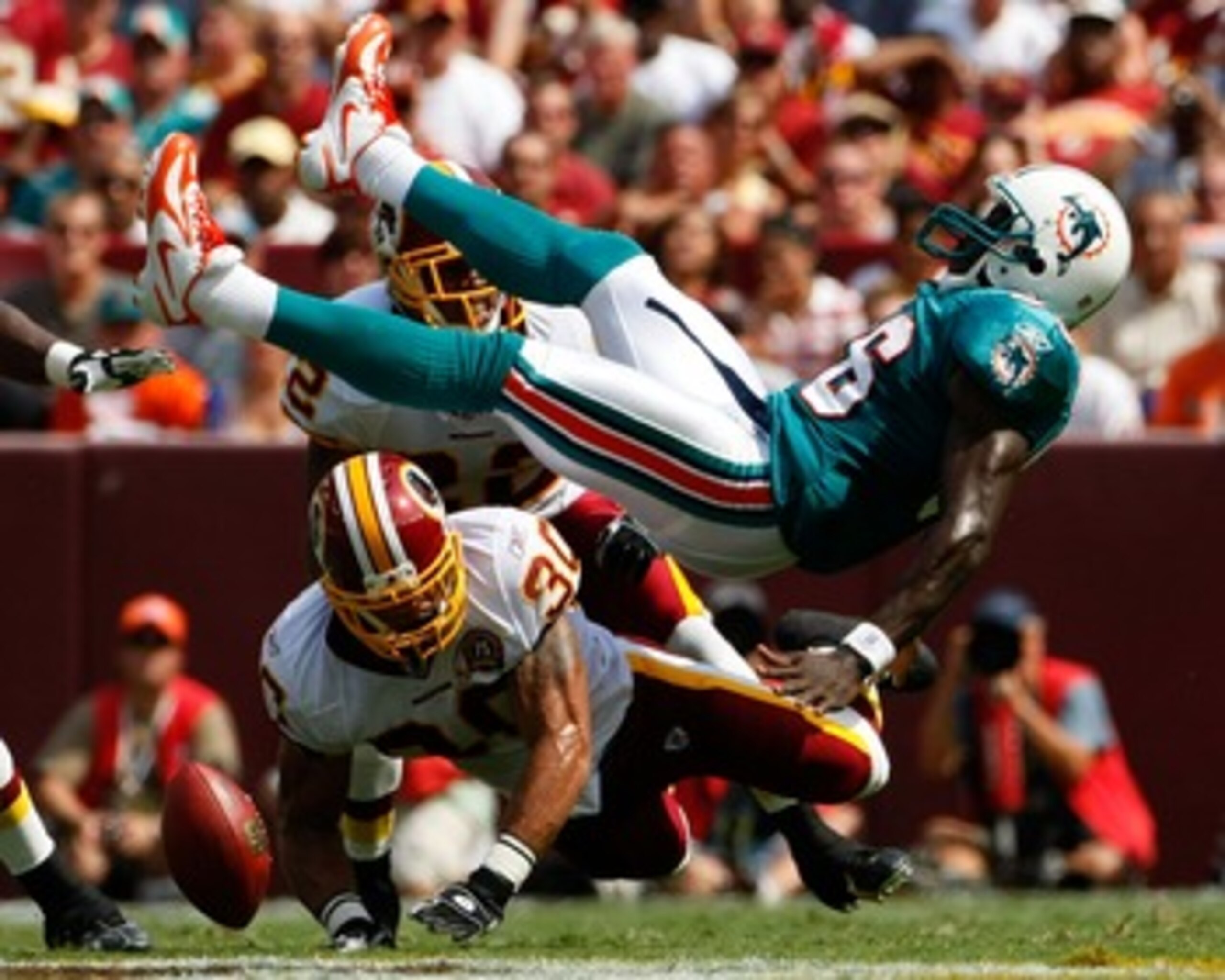 WASHINGTON - SEPTEMBER 09:  Safety LaRon Landry  #30 of the Washington Redskins separates Miami Dolphins wide receiver Marty Booker #86 from the football in second quarter action at FedEx Field September 9, 2007 in Landover, Maryland.  (Photo by Win McNam