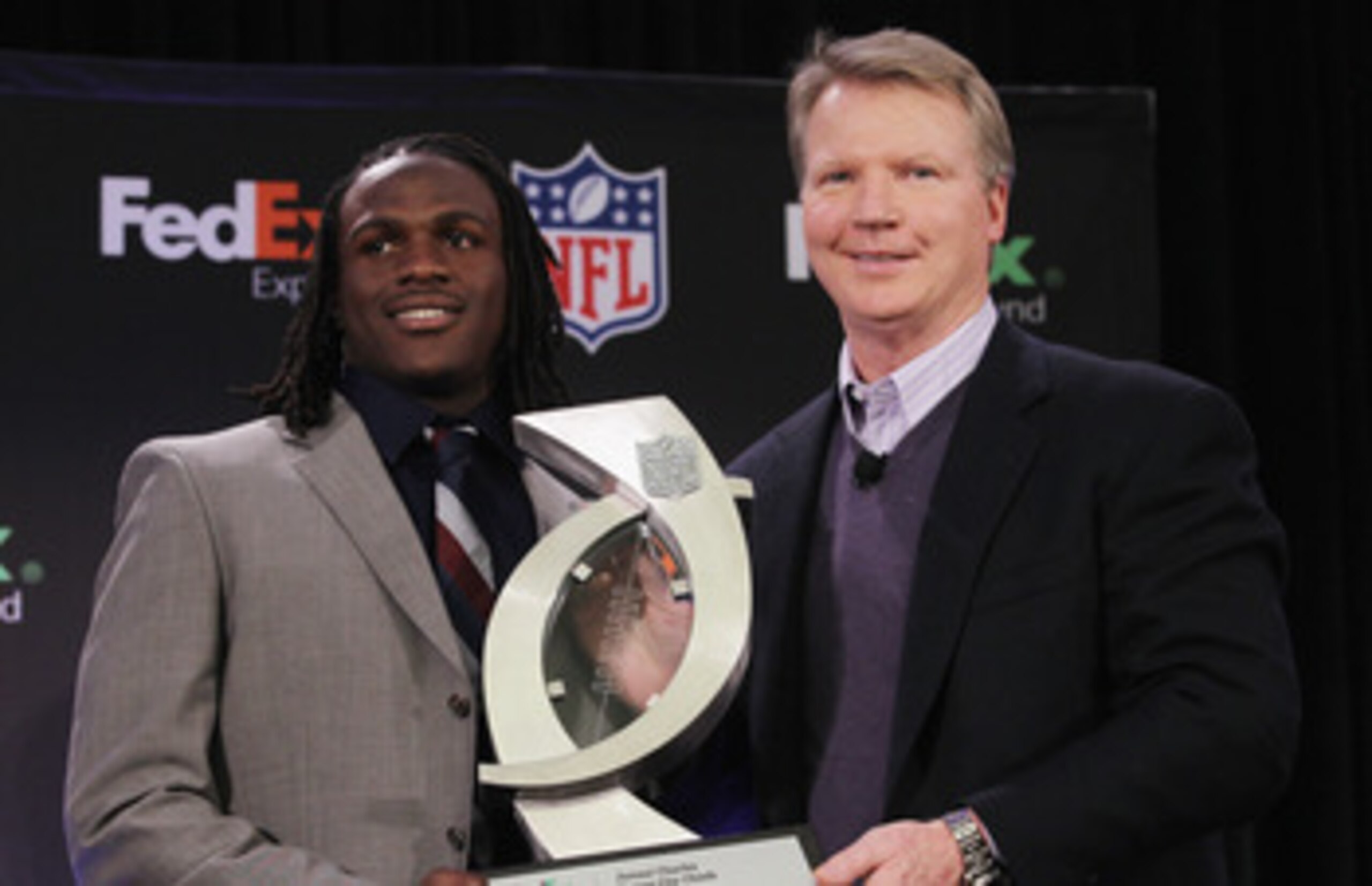 DALLAS, TX - FEBRUARY 02:  Jamaal Charles of the Kansas City Chiefs (L), winner of the FedEx Ground NFL Player of the Year, poses with New York Giants legend Phil Simms at the Super Bowl XLV media center on February 2, 2011 in Dallas, Texas.  (Photo by Ro