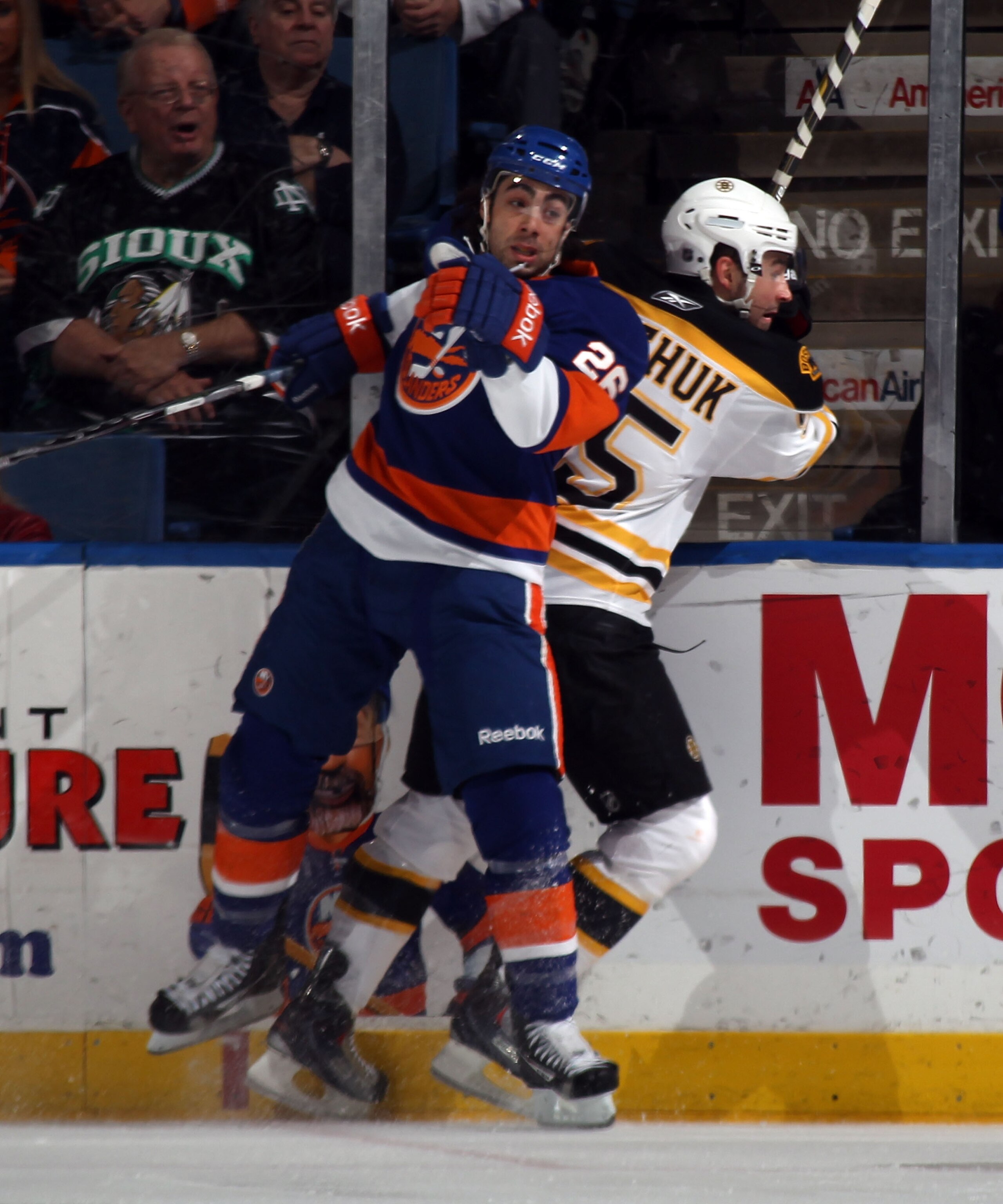 UNIONDALE, NY - MARCH 11: Matt Moulson #26 of the New York Islanders hits Johnny Boychuk #55 of the Boston Bruins at the Nassau Coliseum on March 11, 2011 in Uniondale, New York.  (Photo by Bruce Bennett/Getty Images)