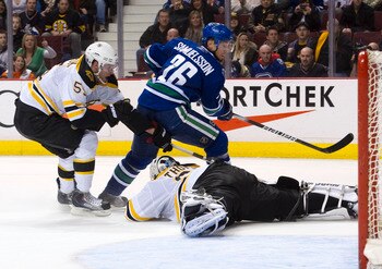 VANCOUVER, CANADA - FEBRUARY 26: Mikael Samuelsson #26 of the Vancouver Canucks is stopped by goalie Tim Thomas #30 of the Boston Bruins while Johnny Boychuck #55 helps on the back check during the second period in NHL action on February 26, 2011 at Roger