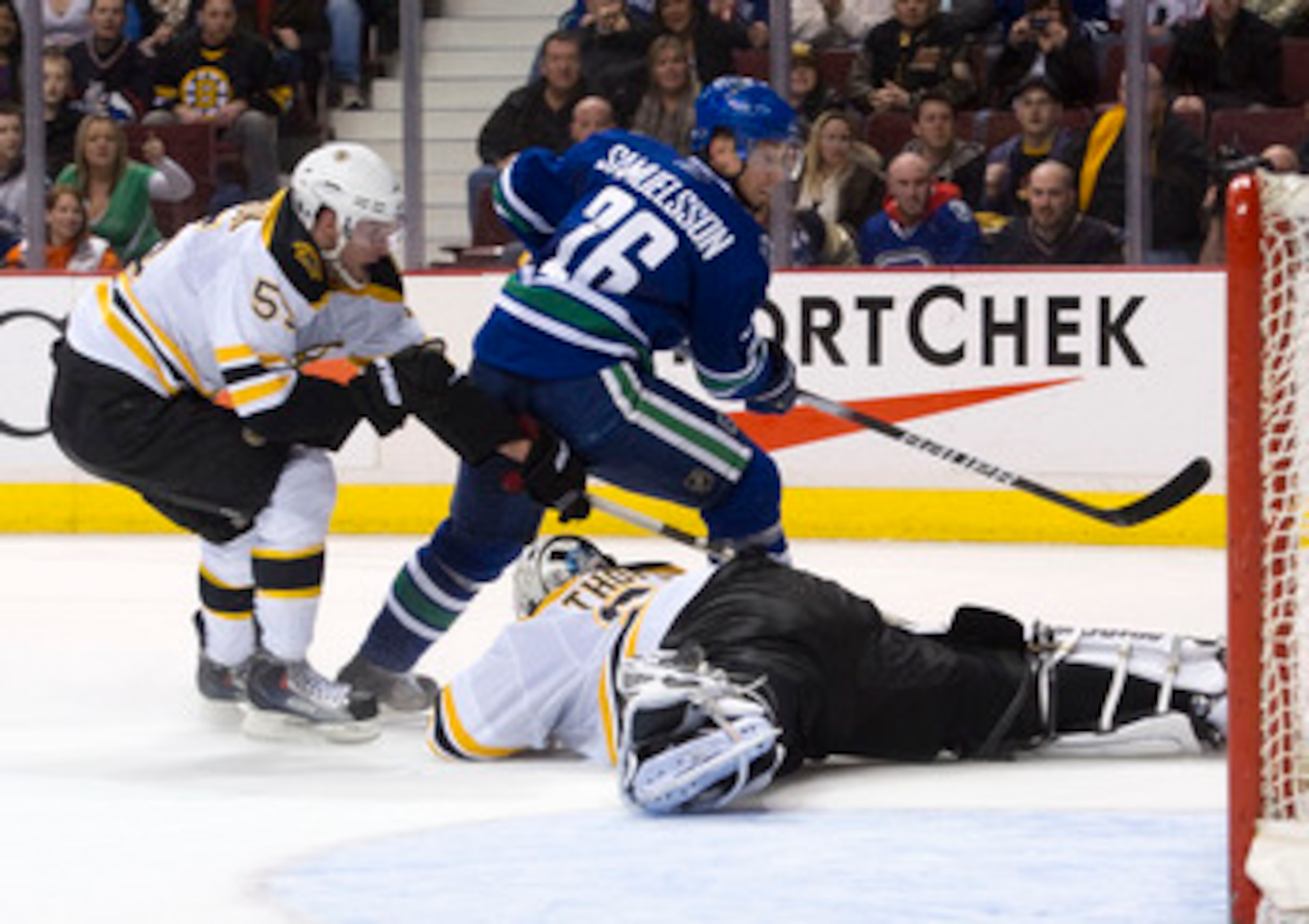 VANCOUVER, CANADA - FEBRUARY 26: Mikael Samuelsson #26 of the Vancouver Canucks is stopped by goalie Tim Thomas #30 of the Boston Bruins while Johnny Boychuck #55 helps on the back check during the second period in NHL action on February 26, 2011 at Roger