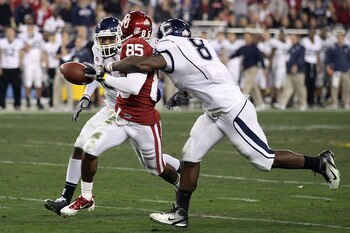 GLENDALE, AZ - JANUARY 01:  Ryan Broyles #85 of the Oklahoma Sooners fumbles the ball as it is stripped by Lawrence Wilson #8 of the Connecticut Huskies alongside Jerome Junior #15 in the second half during the Tostitos Fiesta Bowl at the Universtity of P