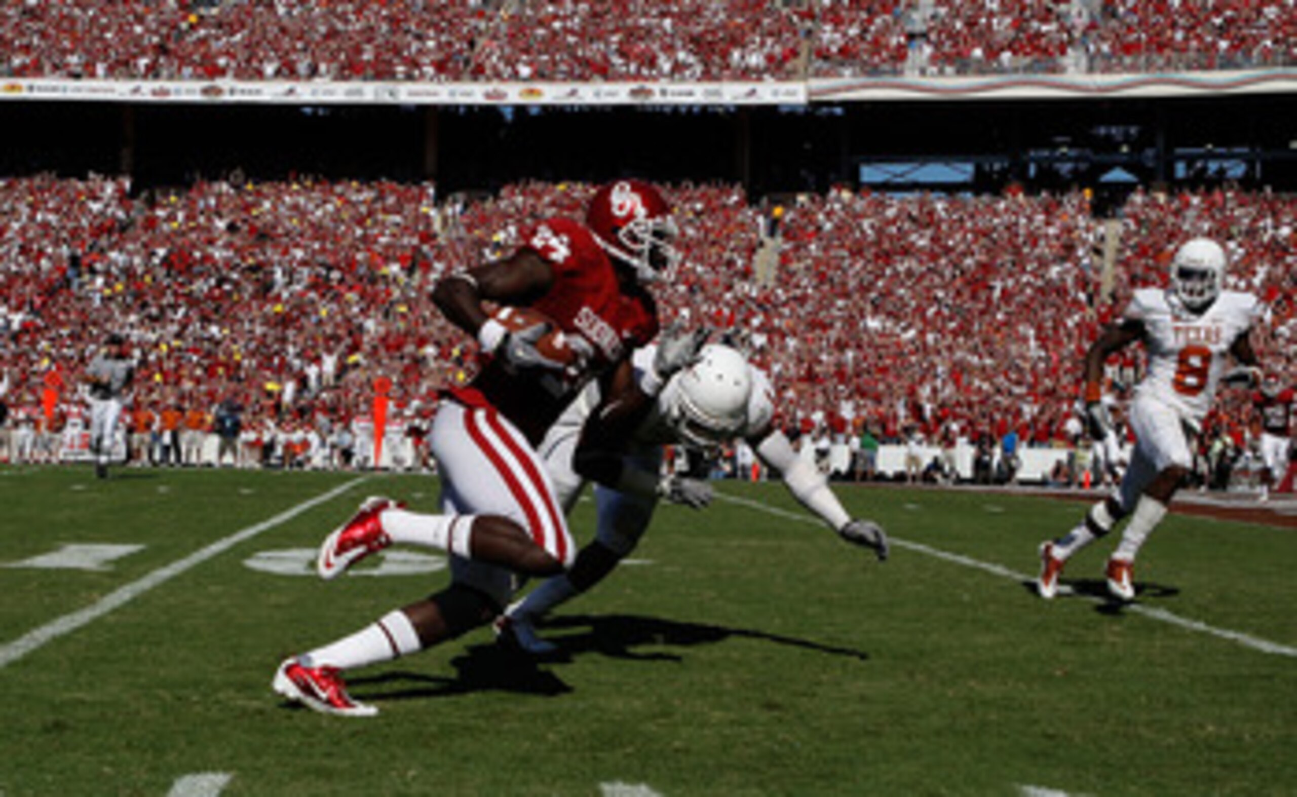 DALLAS - OCTOBER 02:  Wide receiver Dejuan Miller #24 of the Oklahoma Sooners runs the ball against Keenan Robinson #1 of the Texas Longhorns in the second quarter at the Cotton Bowl on October 2, 2010 in Dallas, Texas.  (Photo by Ronald Martinez/Getty Im