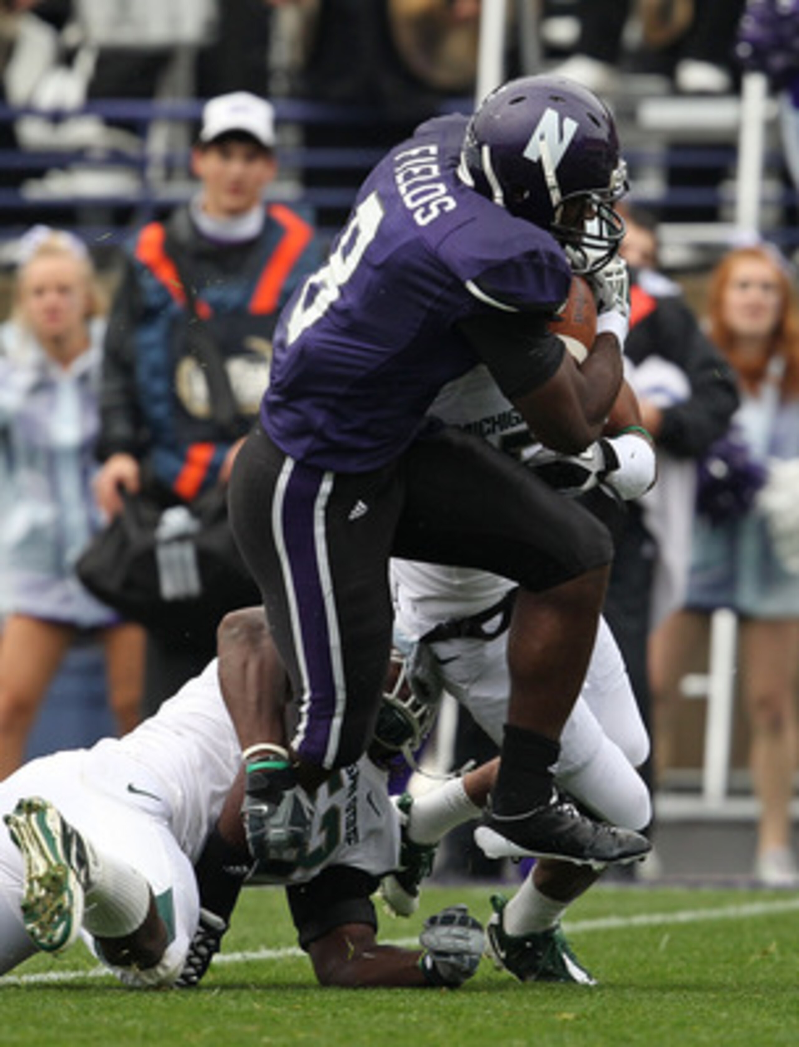 EVANSTON, IL - OCTOBER 23: Demetrius Fields #8 of the Northwestern Wildcats tries to avoid Greg Jones #53 and Johnny Adams #5 of the Michigan State Spartans at Ryan Field on October 23, 2010 in Evanston, Illinois. Michigan State defeated Northwestern 35-2 EVANSTON, IL - OCTOBER 23: Demetrius Fields #8 of the Northwestern Wildcats tries to avoid Greg Jones #53 and Johnny Adams #5 of the Michigan State Spartans at Ryan Field on October 23, 2010 in Evanston, Illinois. Michigan State defeated Northwestern 35-2