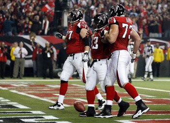 ATLANTA, GA - JANUARY 15:  (L-R) Tyson Clabo #77, Michael Turner #33 and Harvey Dahl #73 of the Atlanta Falcons celebrate after Turner scored a 12-yard rushing touchdown in the first quarter against the Green Bay Packers during their 2011 NFC divisional p