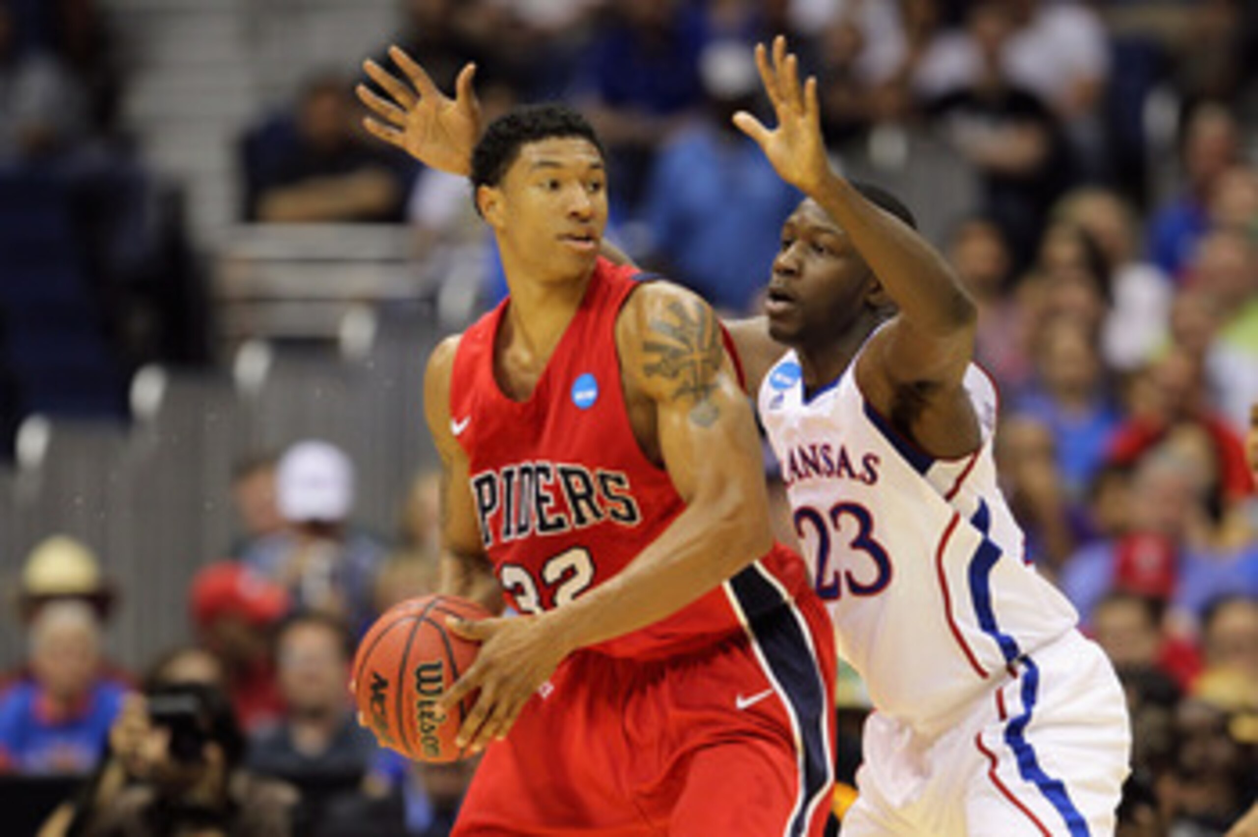SAN ANTONIO, TX - MARCH 25:  Justin Harper #32 of the Richmond Spiders handles the ball against Mario Little #23 of the Kansas Jayhawks during the southwest regional of the 2011 NCAA men's basketball tournament at the Alamodome on March 25, 2011 in San An