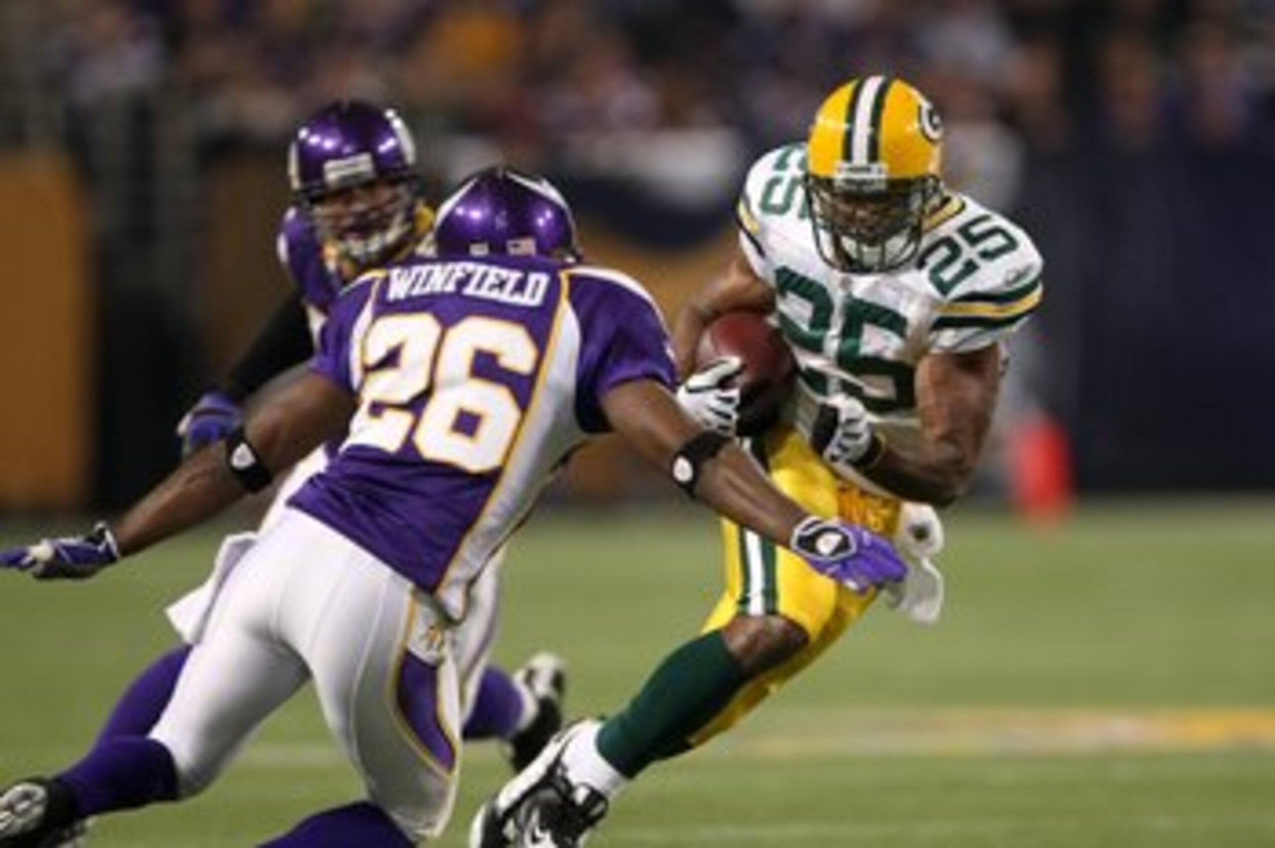 MINNEAPOLIS - NOVEMBER 09:  Running back Ryan Grant #25 of the Green Bay Packers carries the ball against cornerback Antoine Winfield #26 of the Minnesota Vikings on November 9, 2008 at the Metrodome in Mineapolis, Minnesota.  The Vikings won 28-27.  (Pho