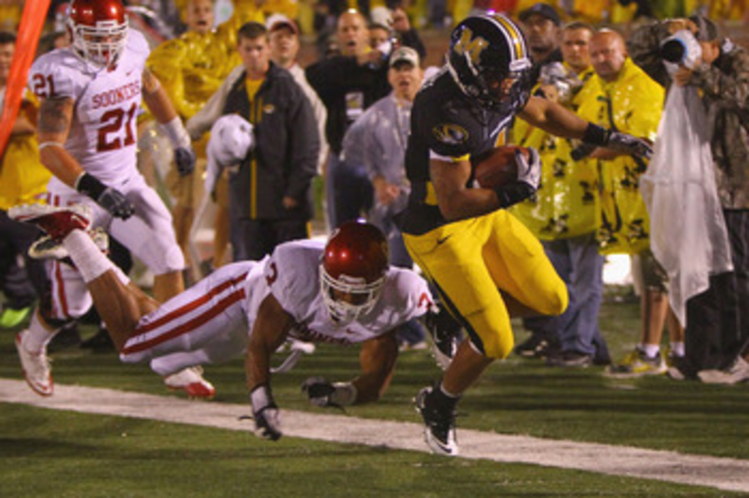 COLUMBIA, MISSOURI - OCTOBER 23: Kendial Lawrence #4 of the Missouri Tigers gets past Jonathan Nelson #3 of the Oklahoma Sooners at Faurot Field/Memorial Stadium on October 23, 2010 in Columbia, Missouri.  The Tigers beat the Sooners 36-27.  (Photo by Dil