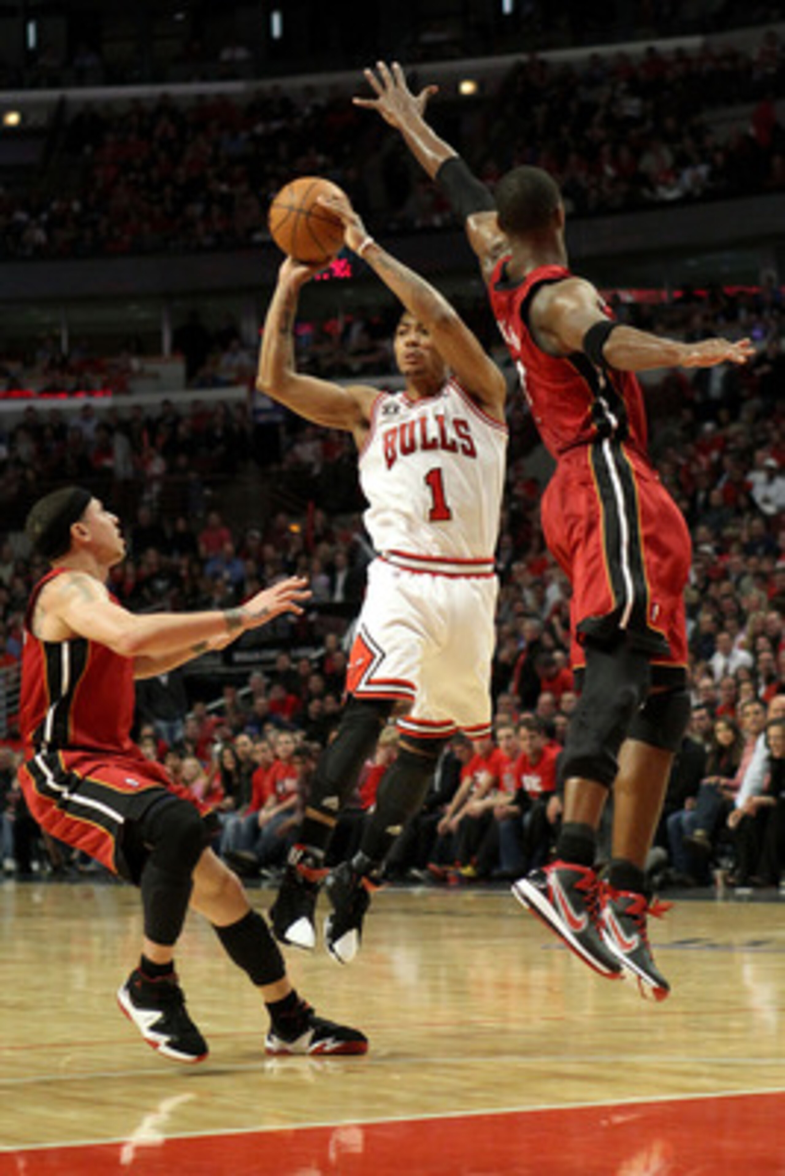 CHICAGO, IL - MAY 26:  Derrick Rose #1 of the Chicago Bulls looks to pass against Chris Bosh #1 and Mike Bibby #0 of the Miami Heat in Game Five of the Eastern Conference Finals during the 2011 NBA Playoffs on May 26, 2011 at the United Center in Chicago,
