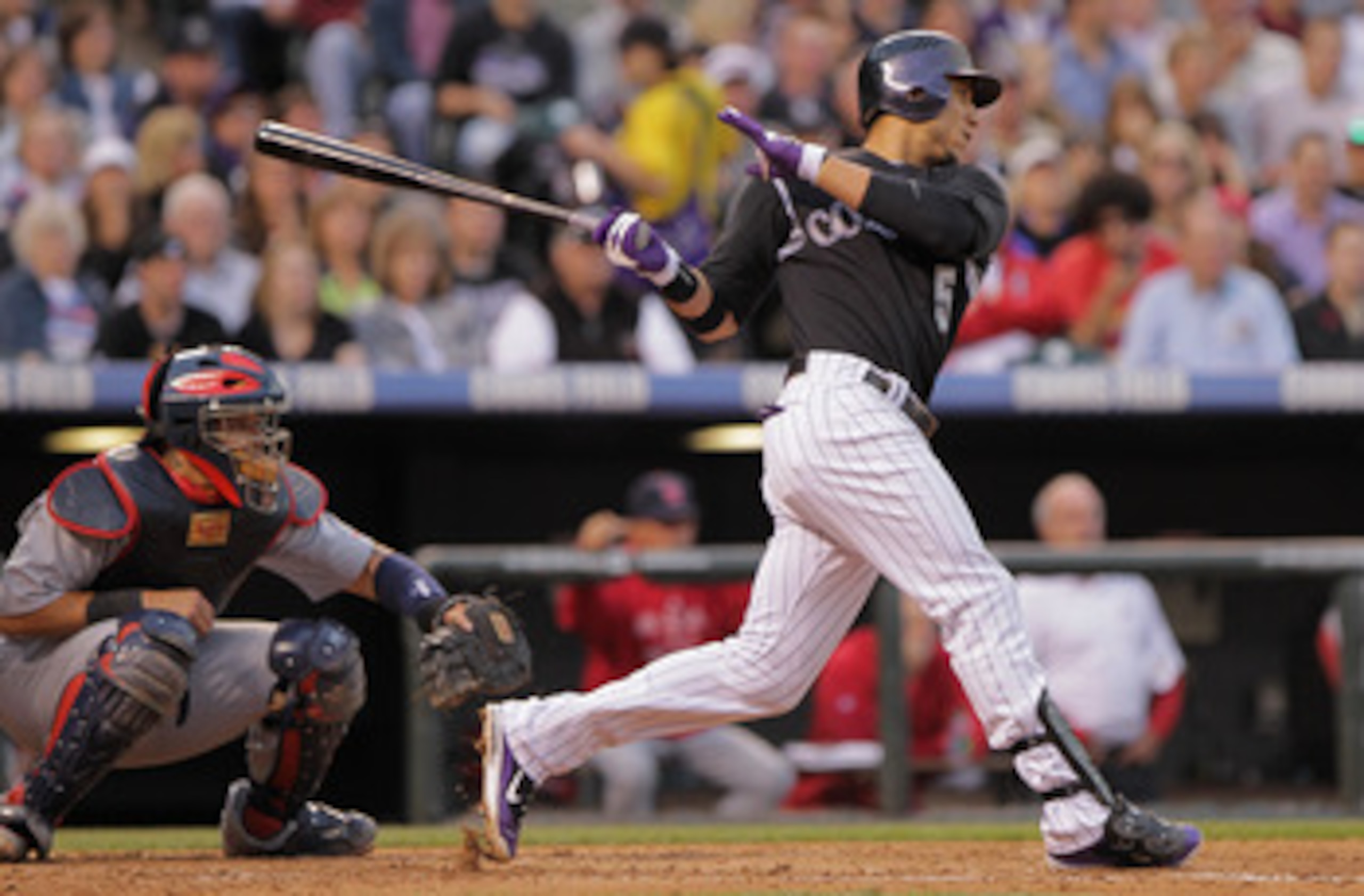 DENVER, CO - MAY 27:  Carlos Gonzalez #5 of the Colorado Rockies hits an RBI single to score Eric Young of the Rockies as catcher Yadier Molina #4 of the St. Louis Cardinals backs up the plate in the third inning at Coors Field on May 27, 2011 in Denver, 