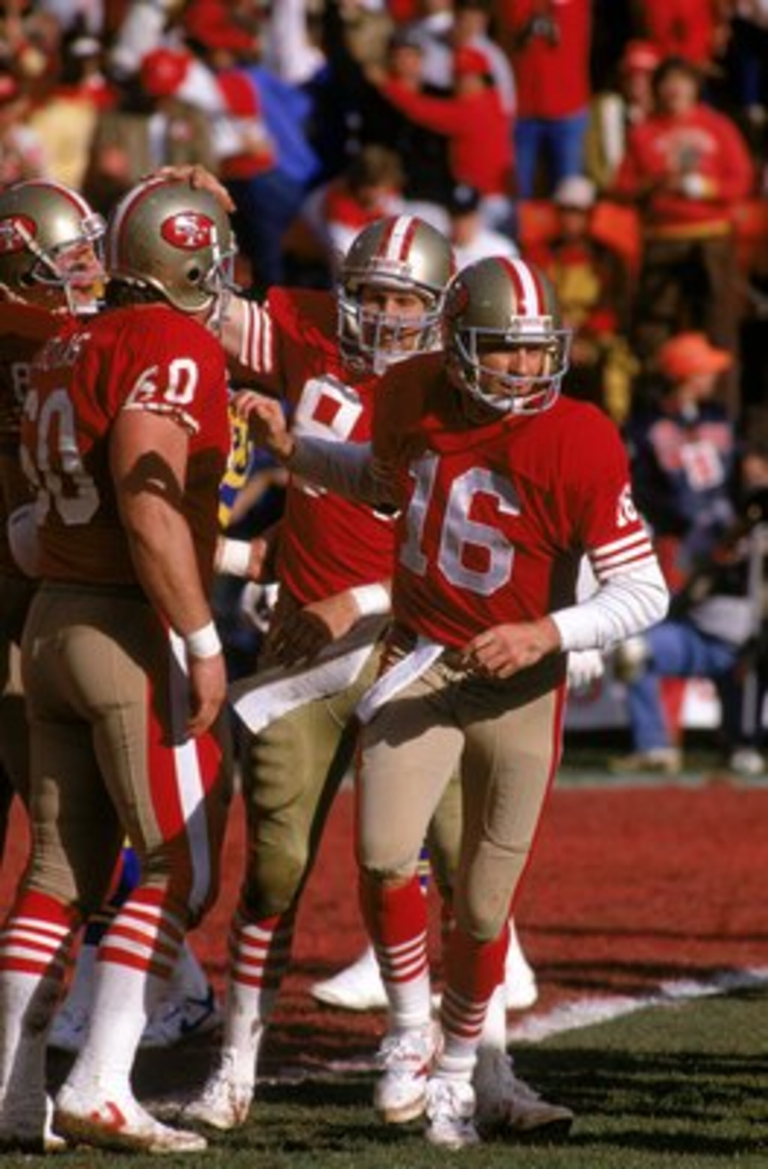 SAN FRANCISCO - JANUARY 14:  Quarterback Joe Montana #16, center Chuck Thomas 60 and tight end Brent Jones #84 of the San Francisco 49ers celebrates a touchdown by Jones during the NFC Championship game against the Los Angeles Rams at Candlestick Park on