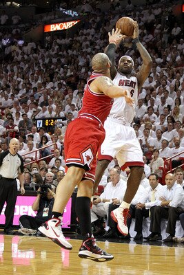 MIAMI, FL - MAY 24:  LeBron James #6 of the Miami Heat attempts a shot as Carlos Boozer #5 of the Chicago Bulls puts his hand over his face in Game Four of the Eastern Conference Finals during the 2011 NBA Playoffs on May 24, 2011 at American Airlines Are