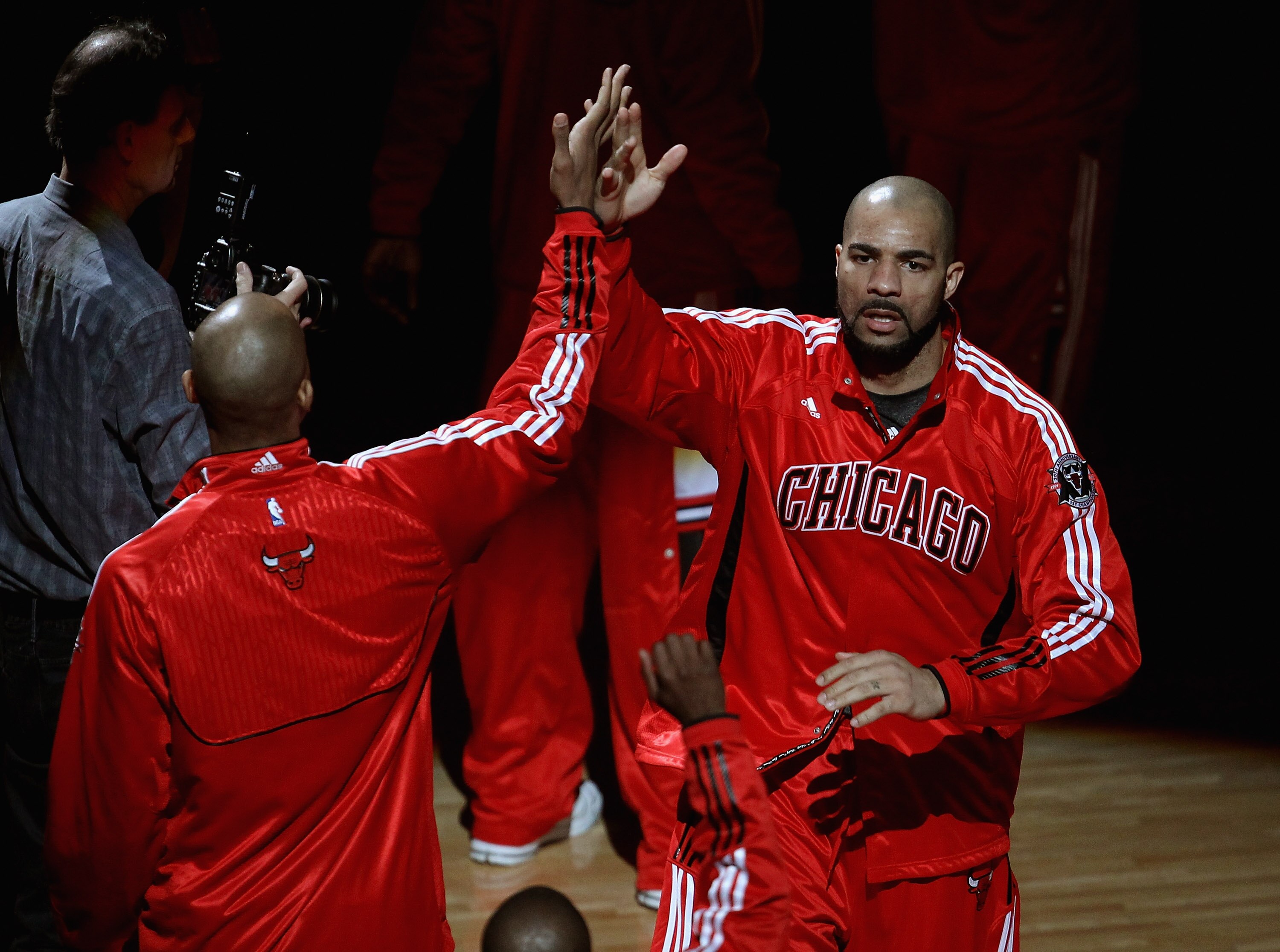 CHICAGO, IL - APRIL 13: Carlos Boozer #5 of the Chicago Bulls is greeted by a teammate during player introductions before a game against the New Jersey Nets at the United Center on April 13, 2011 in Chicago, Illinois. The Bulls defeated the Nets 97-92. NO