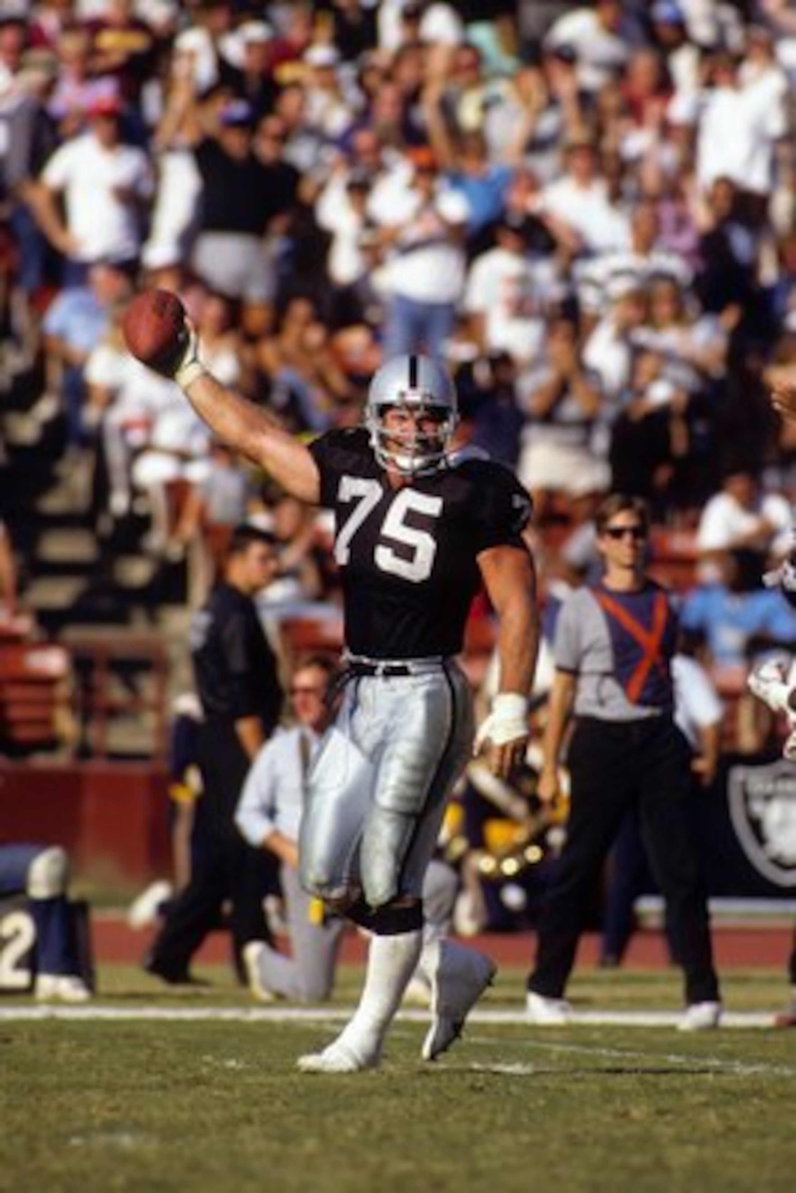 LOS ANGELES - OCTOBER 29:  Defensive end Howie Long #75 of the Los Angeles Raiders holds the football in the air during the game against the Washington Redskins at the Los Angeles Memorial Coliseum on October 29, 1989 in Los Angeles, California.  The Raid