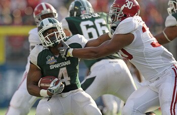 ORLANDO, FL - JANUARY 01:  Edwin Baker #4 of the Michigan State Spartans stiff arms Dont'a Hightower #30 of the Alabama Crimson Tide during the Capitol One Bowl at the Florida Citrus Bowl on January 1, 2011 in Orlando, Florida.  (Photo by Mike Ehrmann/Get