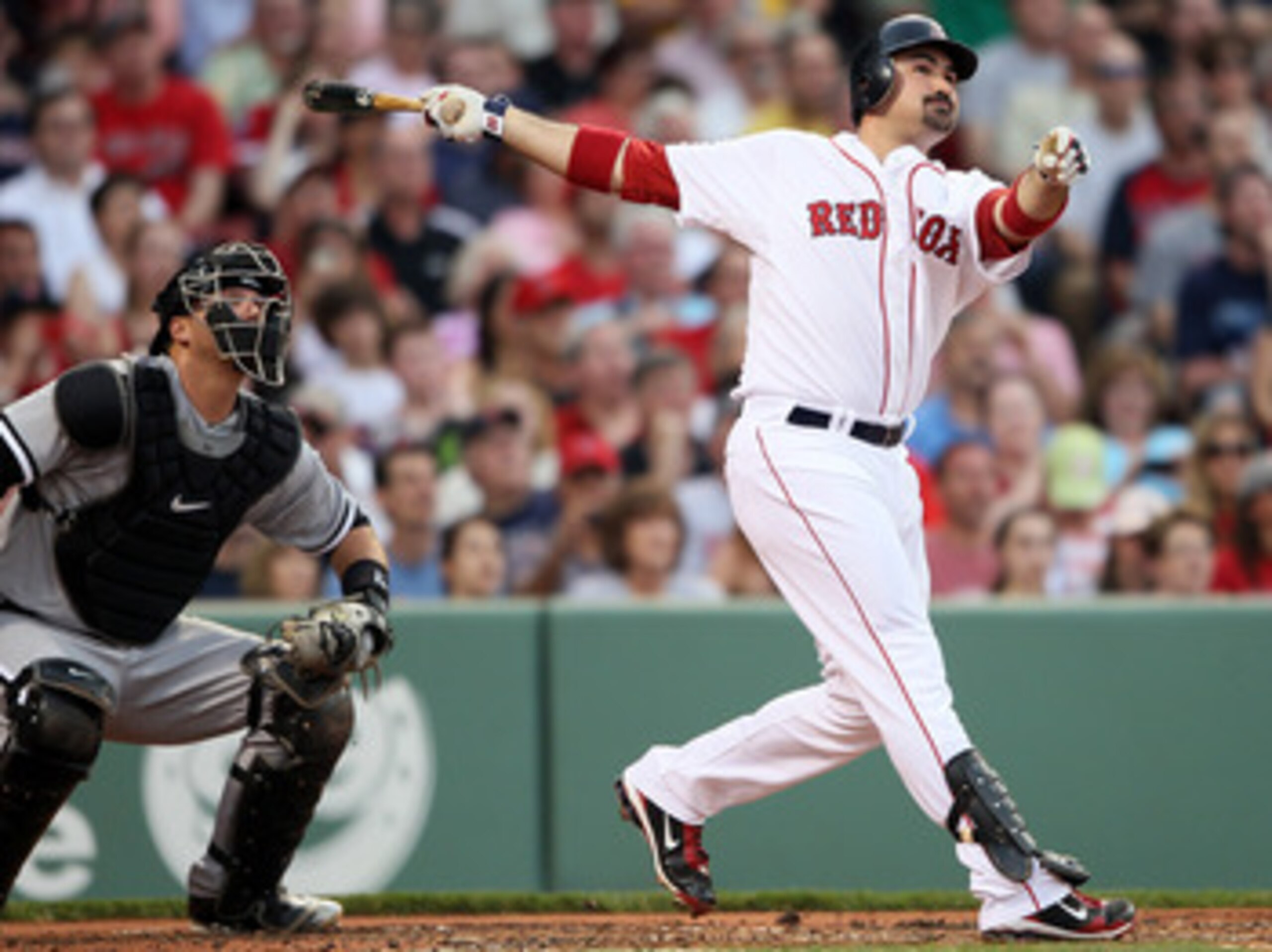 BOSTON, MA - MAY 30:  Adrian Gonzalez #28 of the Boston Red Sox hits a solo home run in the first inning as A.J. Pierzynski #12 of the Chicago White Sox catches on May 30, 2011 at Fenway Park in Boston, Massachusetts.  (Photo by Elsa/Getty Images)