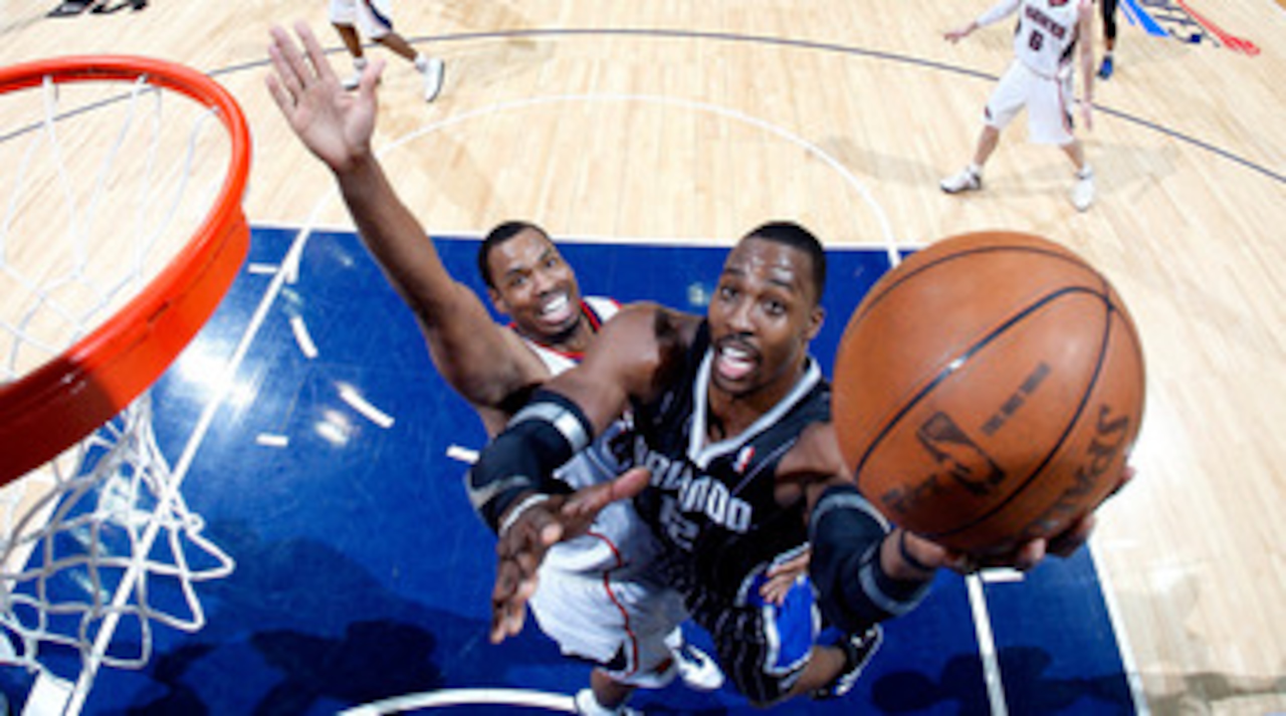 ATLANTA, GA - APRIL 24:  Dwight Howard #12 of the Orlando Magic attacks the basket against Jason Collins #34 of the Atlanta Hawks during Game Four of the Eastern Conference Quarterfinals in the 2011 NBA Playoffs at Philips Arena on April 24, 2011 in Atlan