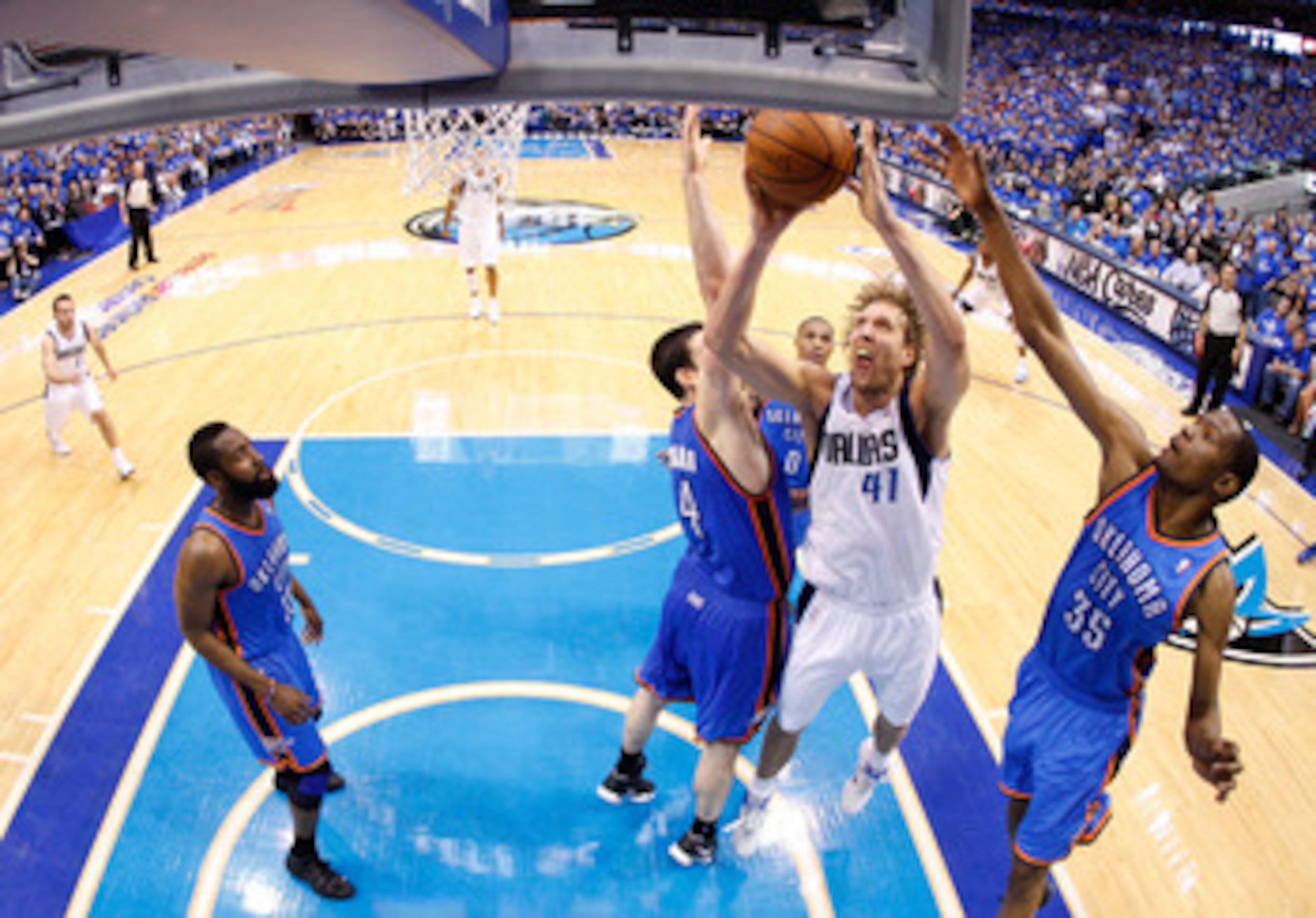 DALLAS, TX - MAY 25:  Dirk Nowitzki #41 of the Dallas Mavericks goes up for a shot between Nick Collison #4 and Kevin Durant #35 of the Oklahoma City Thunder in the second half in Game Five of the Western Conference Finals during the 2011 NBA Playoffs at 