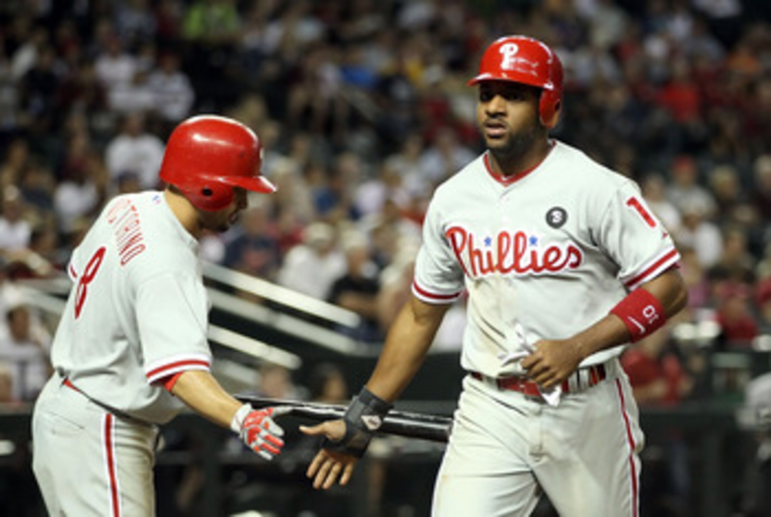 PHOENIX, AZ - APRIL 26:  Ben Francisco #10 of the Philadelphia Phillies high fives teammate Shane Victorino #8 after scoring a sixth inning run against the Arizona Diamondbacks during the Major League Baseball game at Chase Field on April 26, 2011 in Phoe