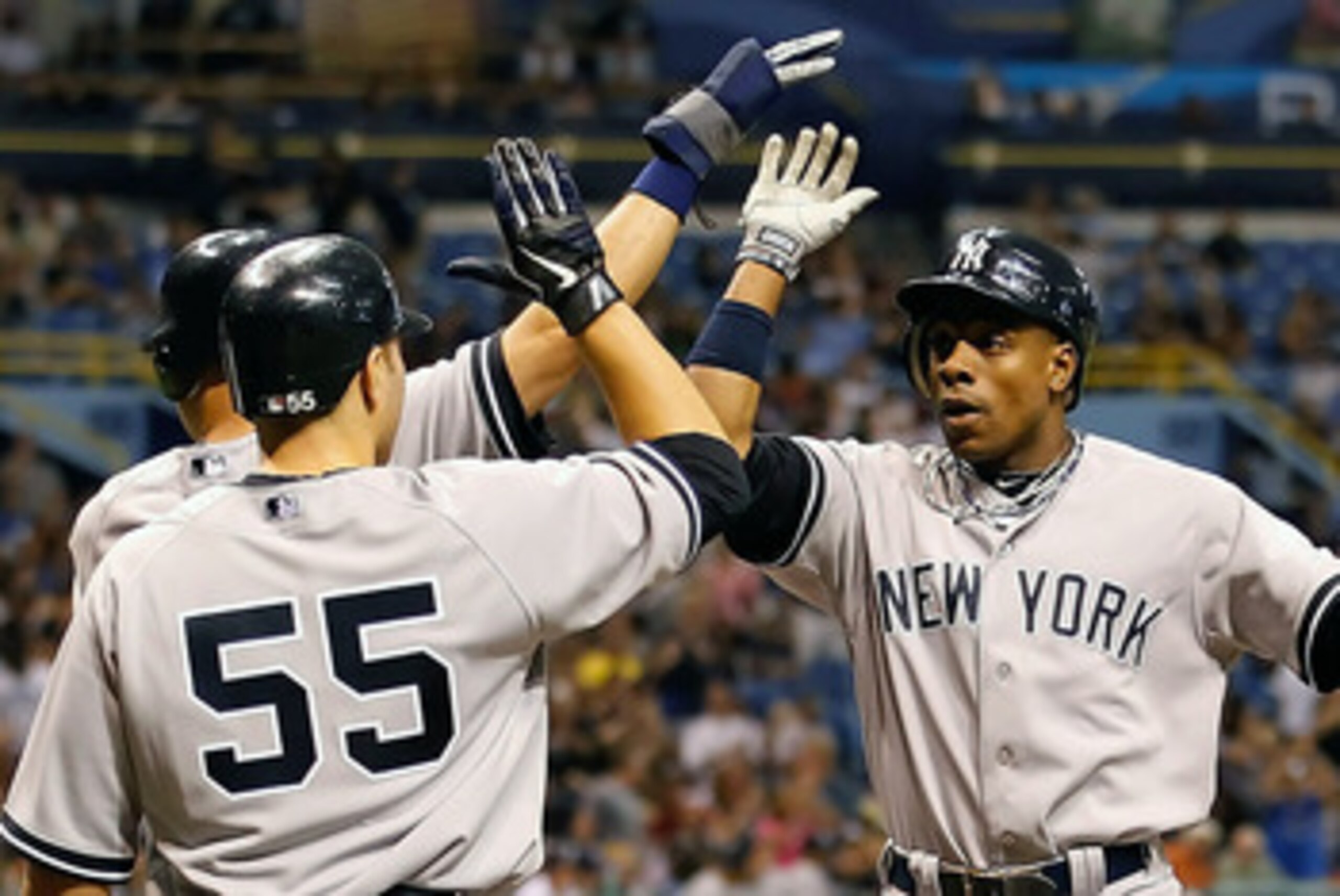 ST. PETERSBURG, FL - MAY 16:  Outfielder Curtis Granderson #14 of the New York Yankees is congratulated by Derek Jeter #2 and Russell Martin #55 after this fifth inning three run home run against the Tampa Bay Rays during the game at Tropicana Field on Ma
