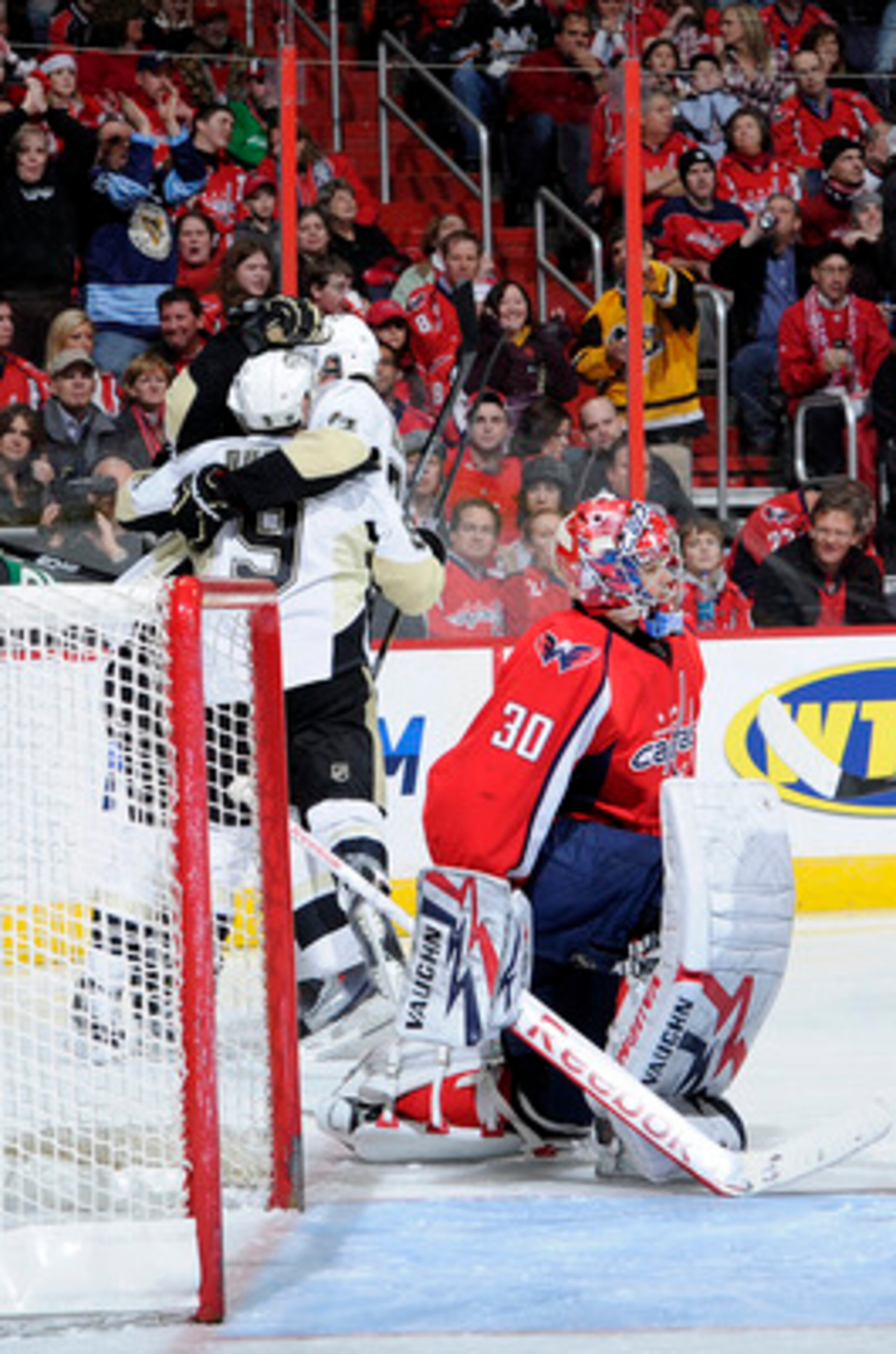 WASHINGTON, DC - DECEMBER 23:  Sidney Crosby #87 of the Pittsburgh Penguins celebrates with teammates after scoring in the first period against Michal Neuvirth #30 of the Washington Capitals  at the Verizon Center on December 23, 2010 in Washington DC.  (