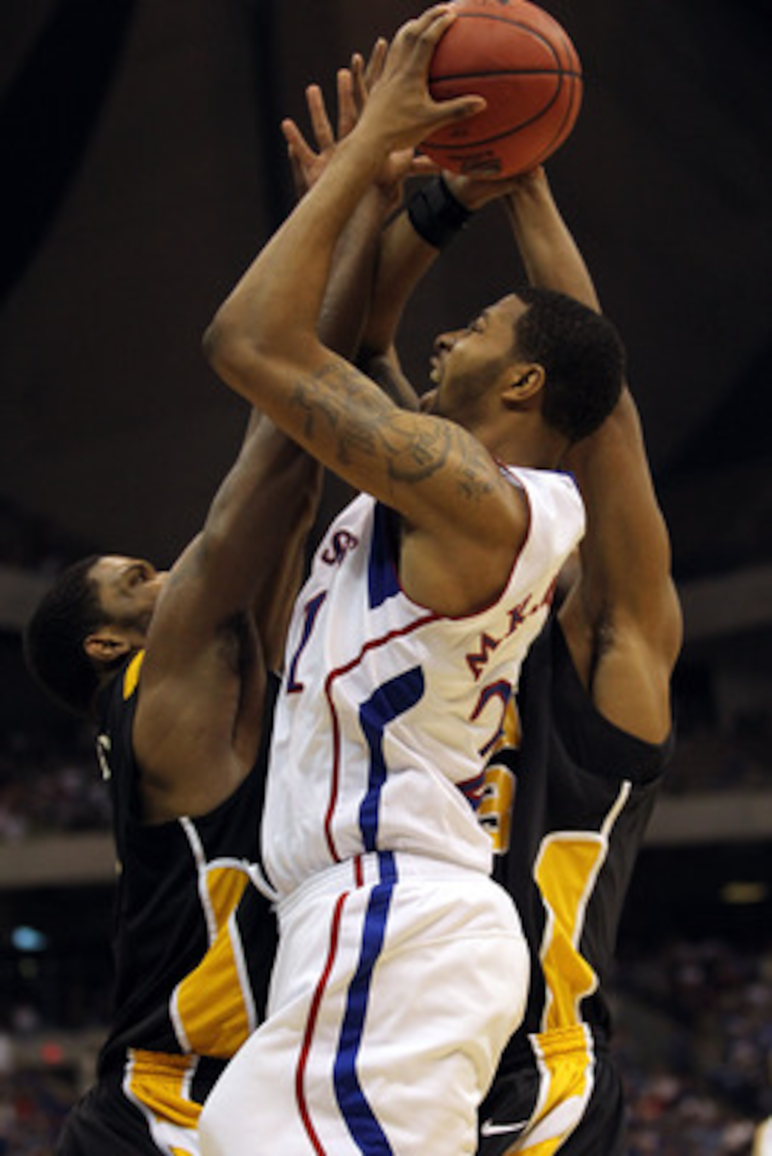 SAN ANTONIO, TX - MARCH 27:  Markieff Morris #21 of the Kansas Jayhawks shoots against Jamie Skeen #21 of the Virginia Commonwealth Rams during the southwest regional final of the 2011 NCAA men's basketball tournament at the Alamodome on March 27, 2011 in
