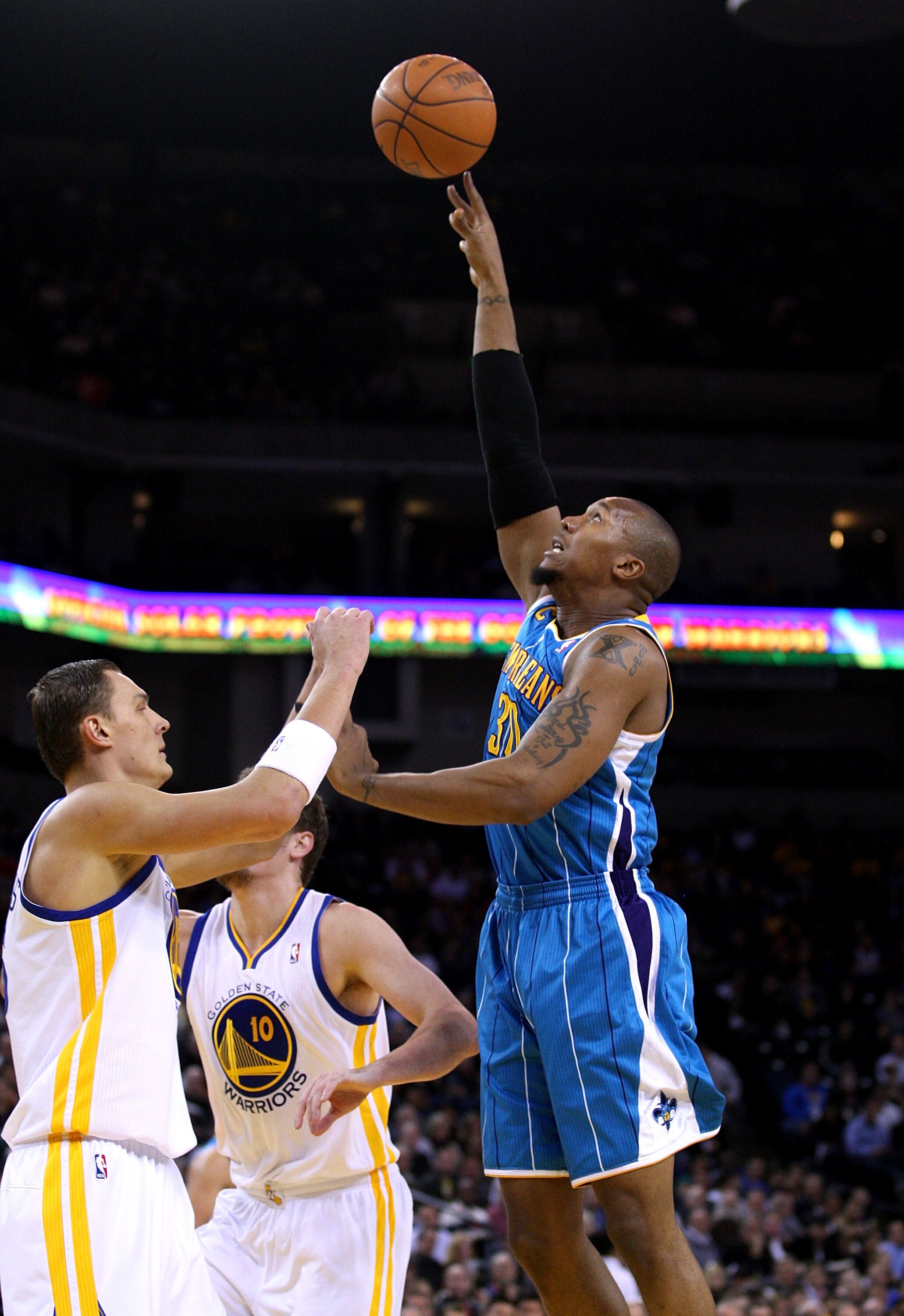 OAKLAND, CA - JANUARY 26:  David West #30 of the New Orleans Hornets shoots over Andris Biedrins #15 of the Golden State Warriors at Oracle Arena on January 26, 2011 in Oakland, California.  NOTE TO USER: User expressly acknowledges and agrees that, by do