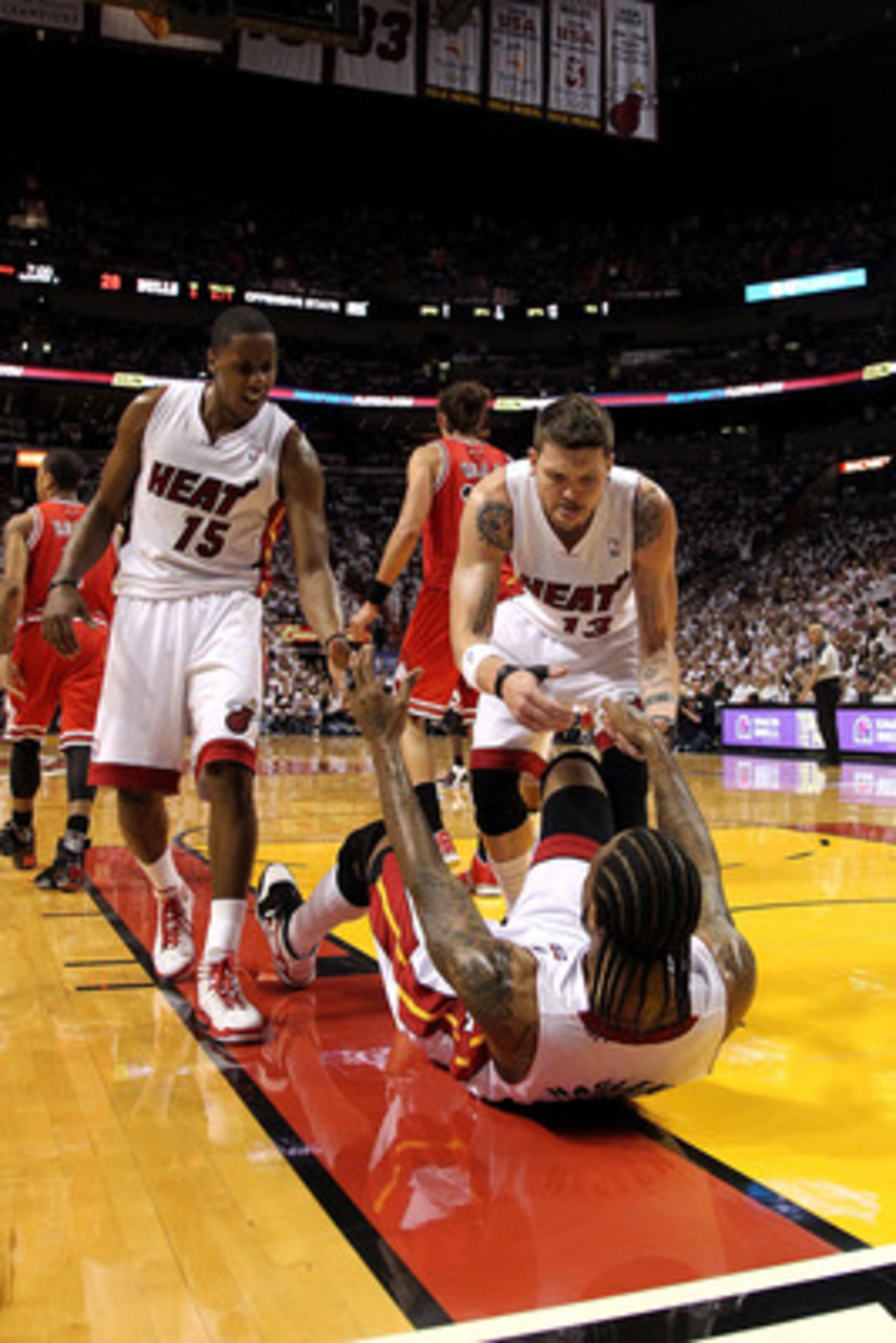MIAMI, FL - MAY 24:  Mario Chalmers #15 and Mike Miller #13 of the Miami Heat react as they help up Udonis Haslem #40 of the Miami Heat against the Chicago Bulls  in Game Four of the Eastern Conference Finals during the 2011 NBA Playoffs on May 24, 2011 a