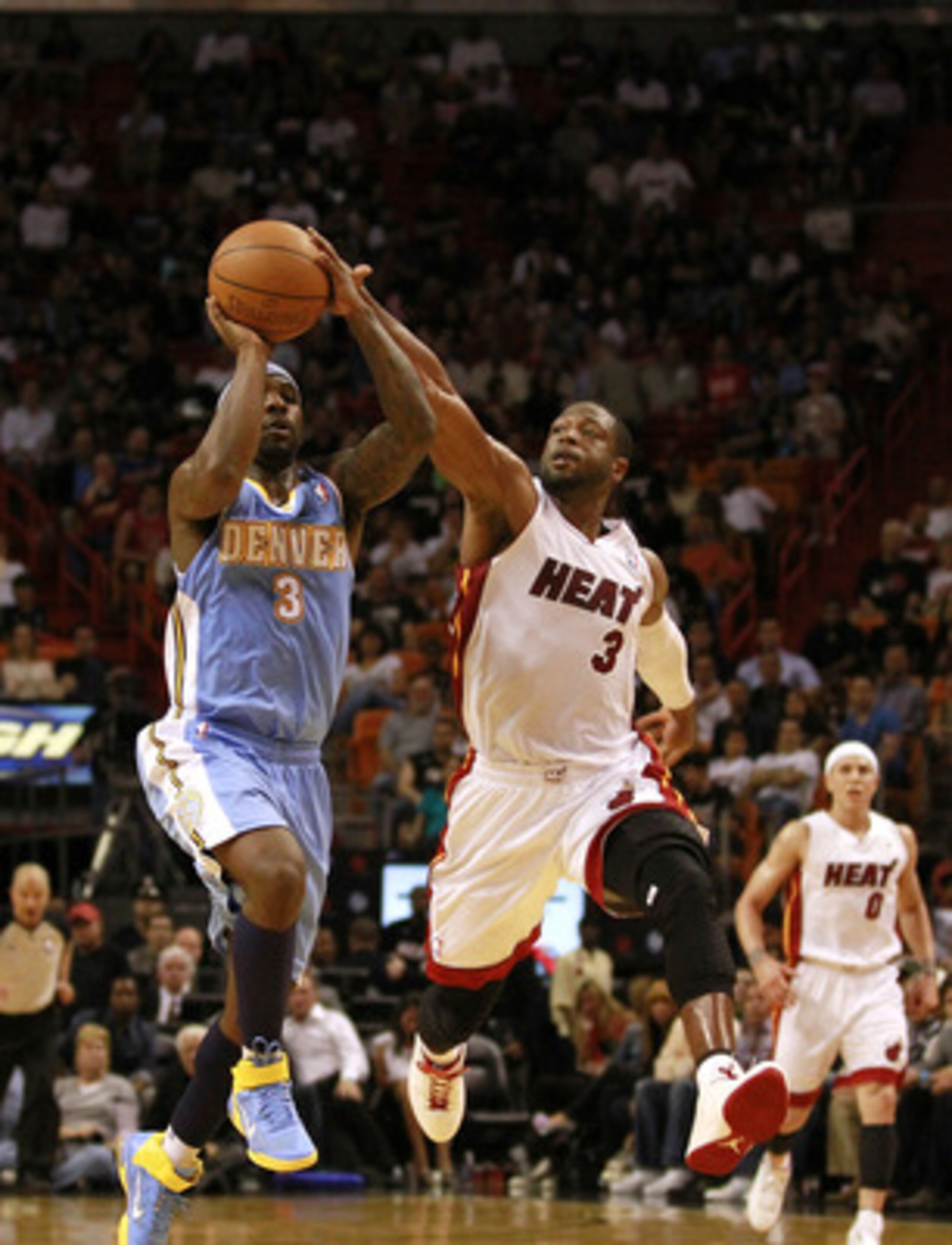 MIAMI, FL - MARCH 19:  Guard Dwyane Wade #3 of the Miami Heat blocks the shot of guard Ty Lawson #3 (R) of the Denver Nuggets at American Airlines Arena on March 19, 2011 in Miami, Florida. NOTE TO USER: User expressly acknowledges and agrees that, by dow