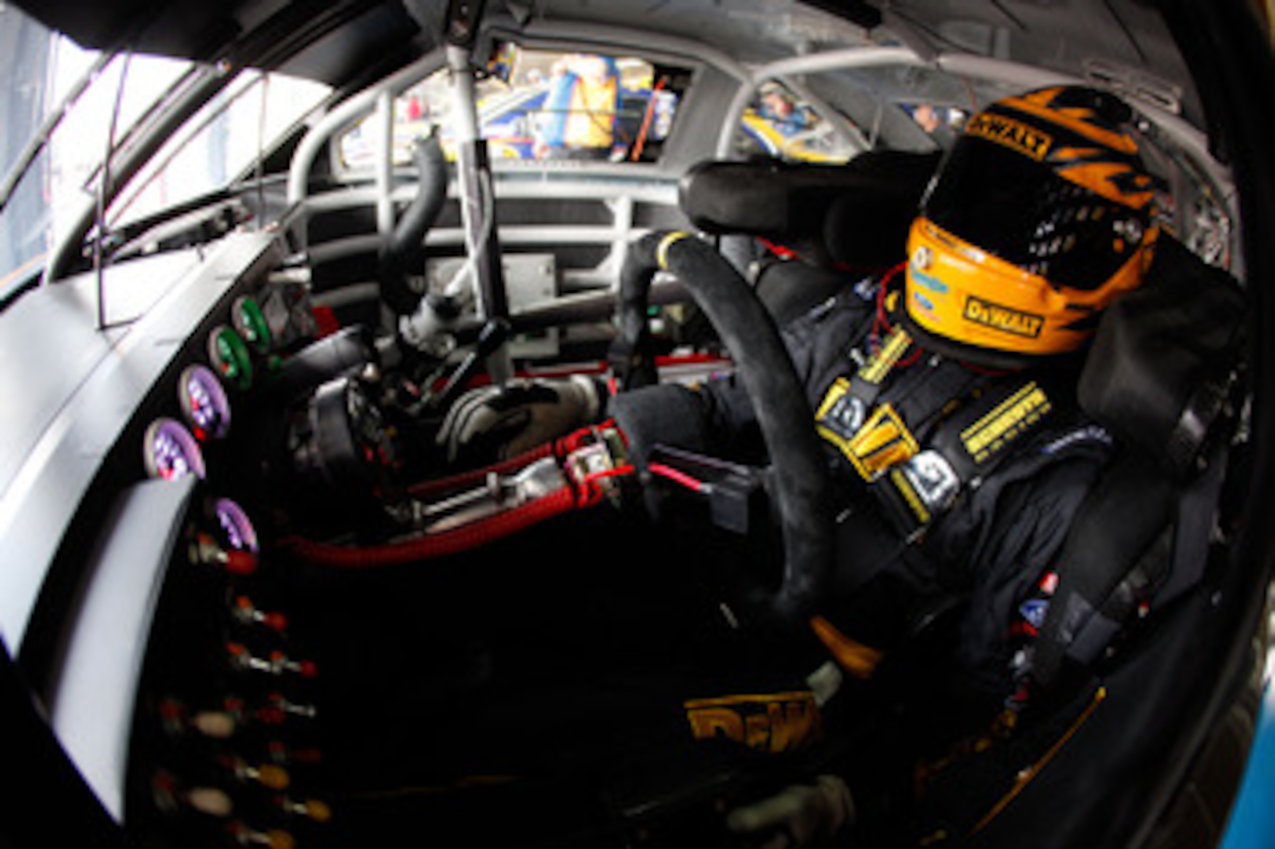 CHARLOTTE, NC - MAY 28:  Marcos Ambrose, driver of the #9 Dewalt Ford, sits in his car during practice for the NASCAR Sprint Cup Series Coca-Cola 600 at Charlotte Motor Speedway on May 28, 2011 in Charlotte, North Carolina.  (Photo by Chris Graythen/Getty