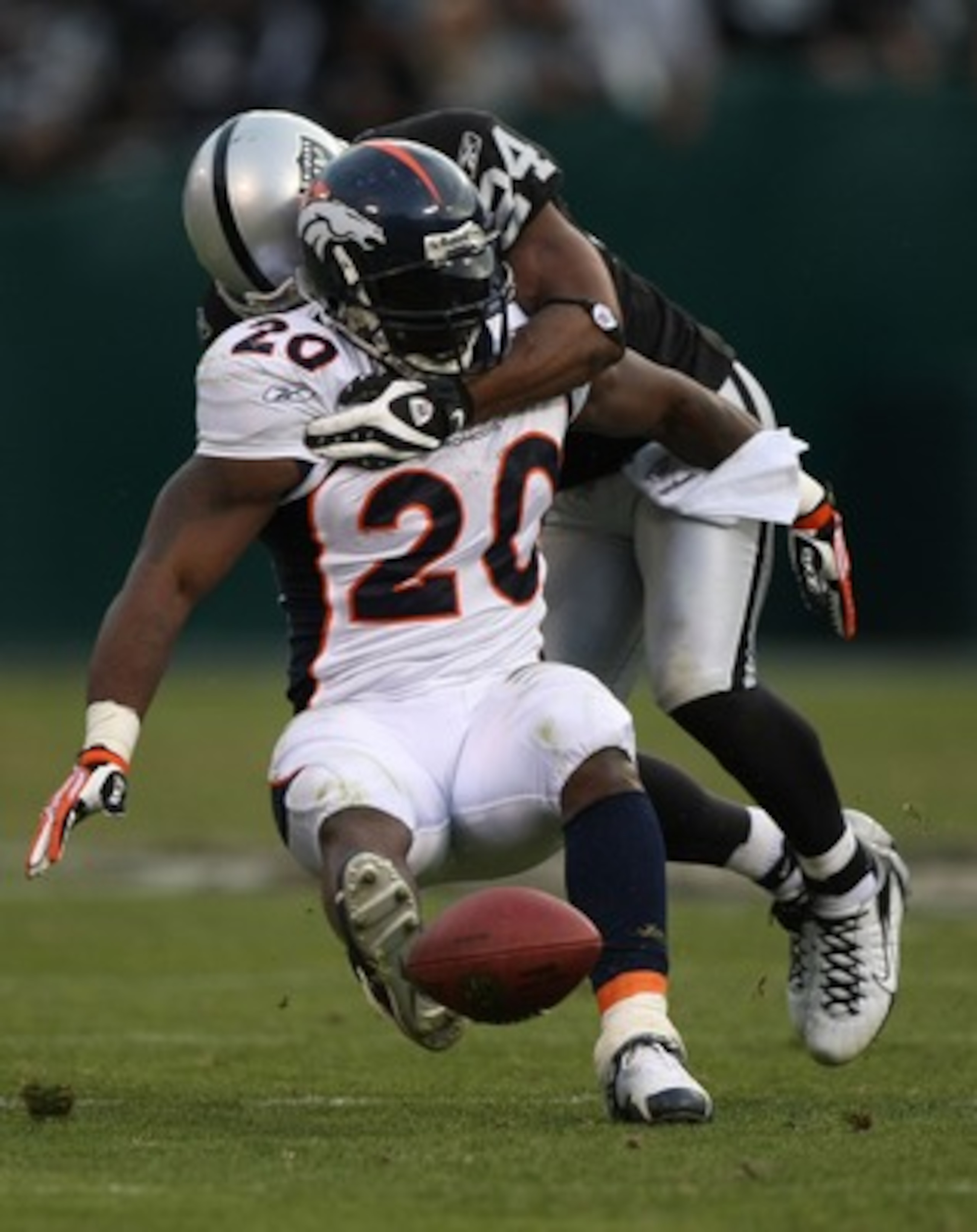 OAKLAND, CA - DECEMBER 2:  Travis Henry #20 of the Denver Broncos is tackled by Michael Huff #24 of the Oakland Raiders during an NFL game December 2, 2007 at McAfee Coliseum in Oakland, California.  (Photo by Jed Jacobsohn/Getty Images)