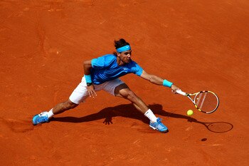 PARIS, FRANCE - MAY 28:  Rafael Nadal of Spain stretches to hit a forehand during the men's singles round three match between Rafael Nadal of Spain and Antonio Veic of Croatia on day seven of the French Open at Roland Garros on May 28, 2011 in Paris, Fran