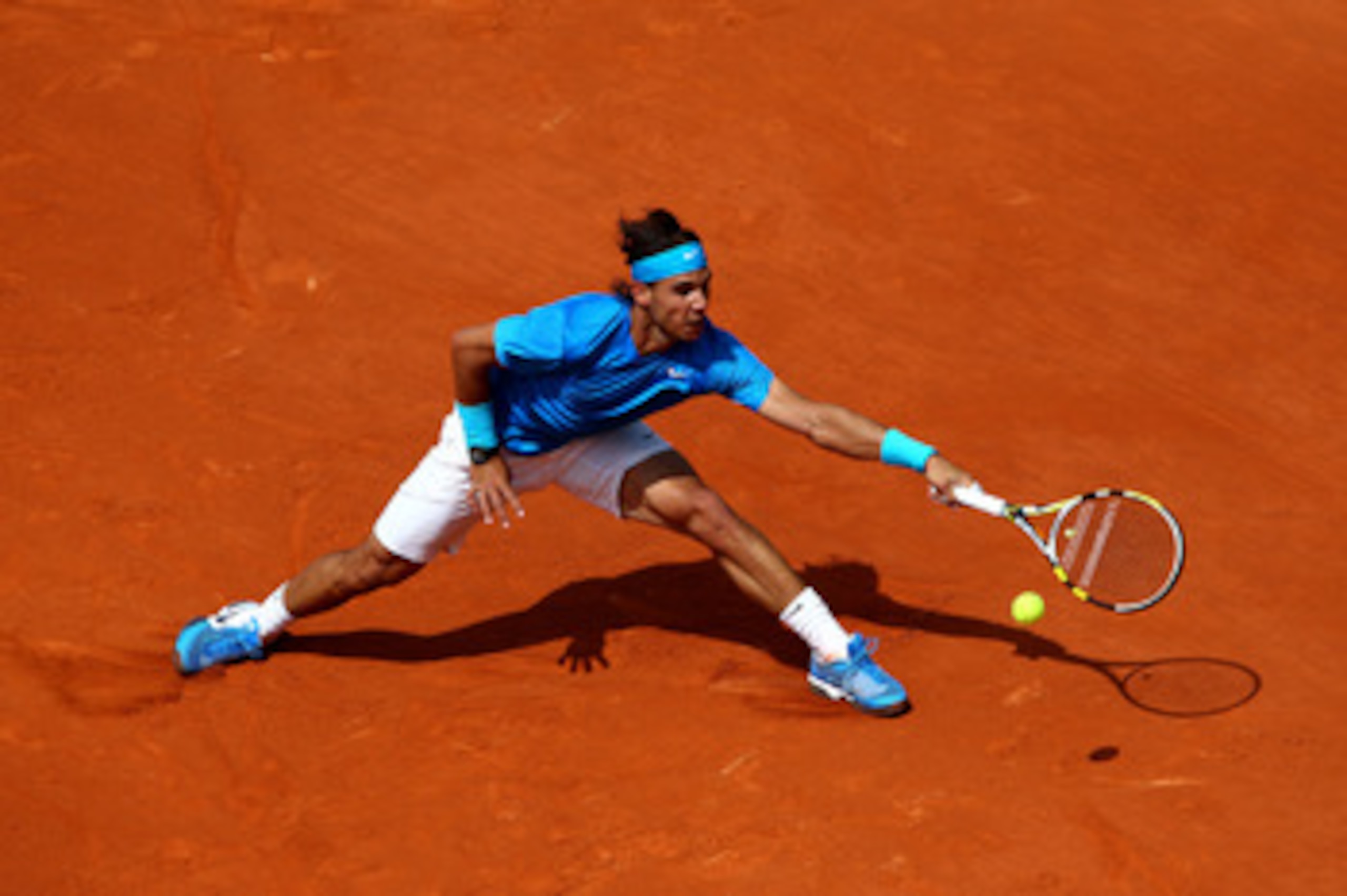 PARIS, FRANCE - MAY 28:  Rafael Nadal of Spain stretches to hit a forehand during the men's singles round three match between Rafael Nadal of Spain and Antonio Veic of Croatia on day seven of the French Open at Roland Garros on May 28, 2011 in Paris, Fran