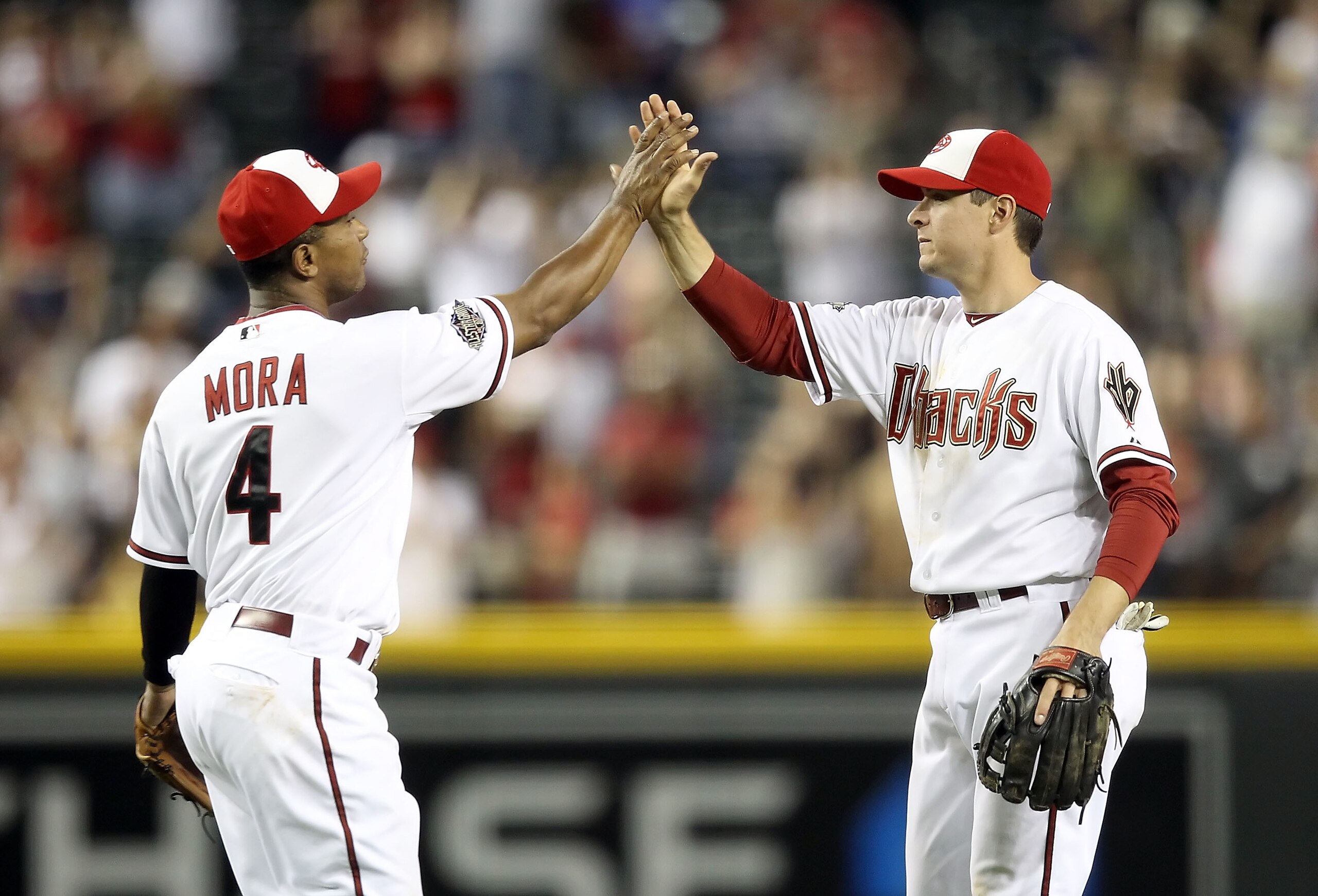 PHOENIX, AZ - MAY 30: Kelly Johnson #2 of the Arizona Diamondbacks high fives teammate Melvin Mora #4 after defeating the Florida Marlins in the Major League Baseball game at Chase Field on May 30, 2011 in Phoenix, Arizona. The Diamondbacks defeated the PHOENIX, AZ - MAY 30: Kelly Johnson #2 of the Arizona Diamondbacks high fives teammate Melvin Mora #4 after defeating the Florida Marlins in the Major League Baseball game at Chase Field on May 30, 2011 in Phoenix, Arizona. The Diamondbacks defeated the