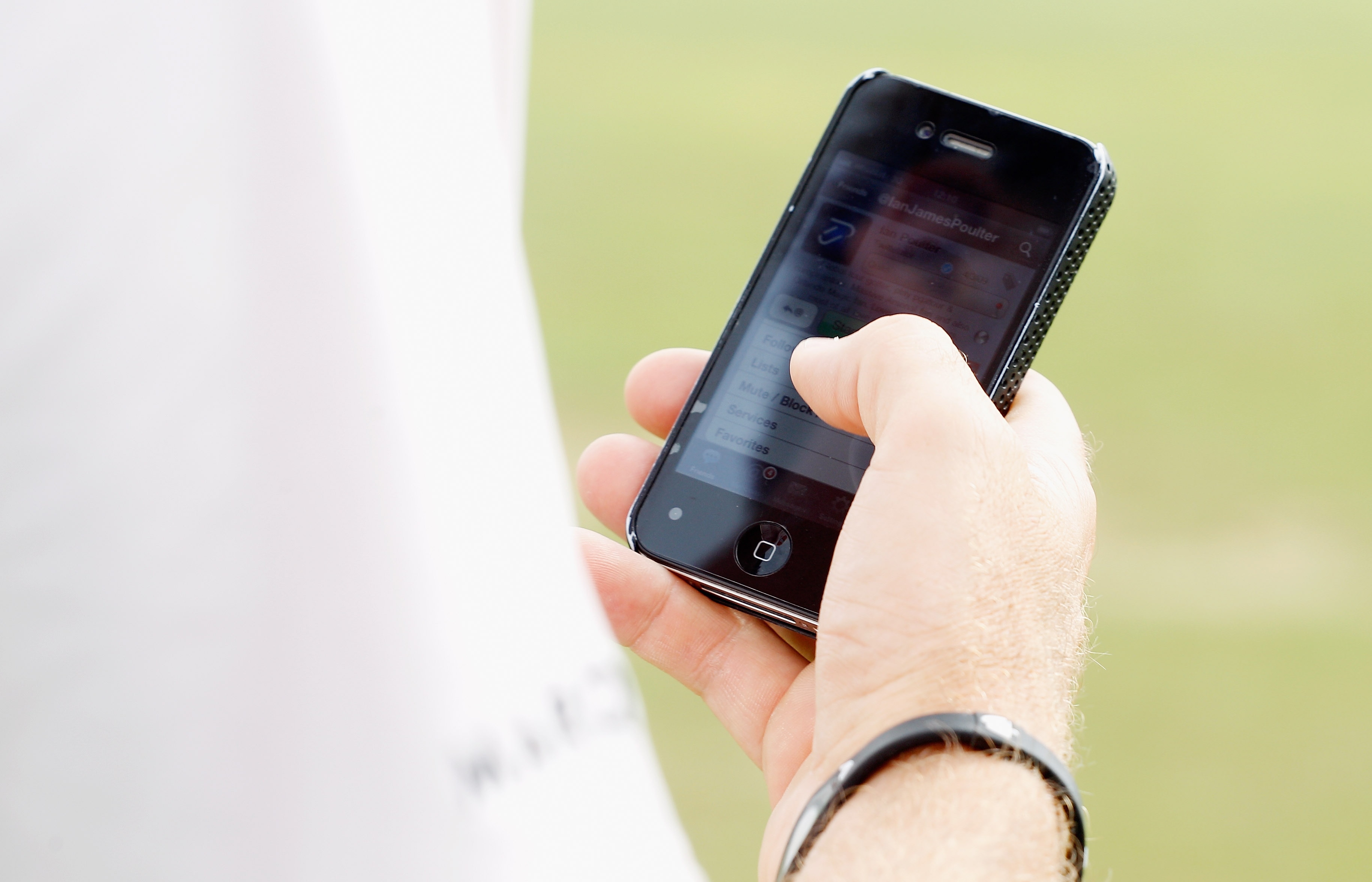 ABU DHABI, UNITED ARAB EMIRATES - JANUARY 23:  Ian Poulter of England sends a message on Twitter on the practice ground during the final round of the 2011 Abu Dhabi HSBC Golf Championship at the Abu Dhabi Golf Club on January 23, 2011 in Abu Dhabi, United