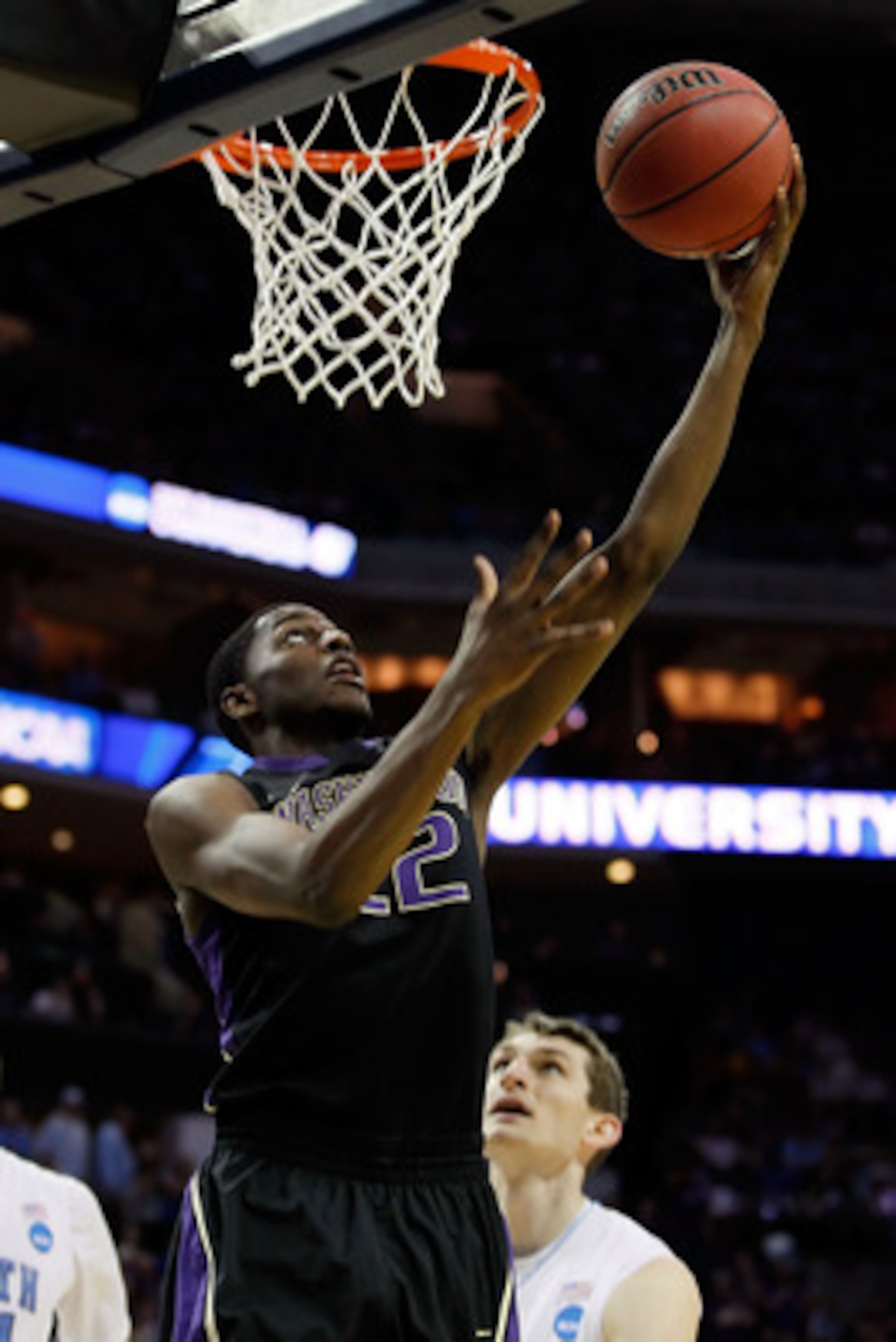 CHARLOTTE, NC - MARCH 20:  Justin Holiday #22 of the Washington Huskies lays the ball up against the North Carolina Tar Heels in the second half during the third round of the 2011 NCAA men's basketball tournament at Time Warner Cable Arena on March 20, 20