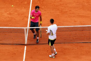 PARIS - MAY 31:  Robin Soderling (below net) of Sweden goes to shake hands with Rafael Nadal of Spain following his victory during the Men's Singles Fourth Round  match on day eight of the French Open at Roland Garros on May 31, 2009 in Paris, France.  (P