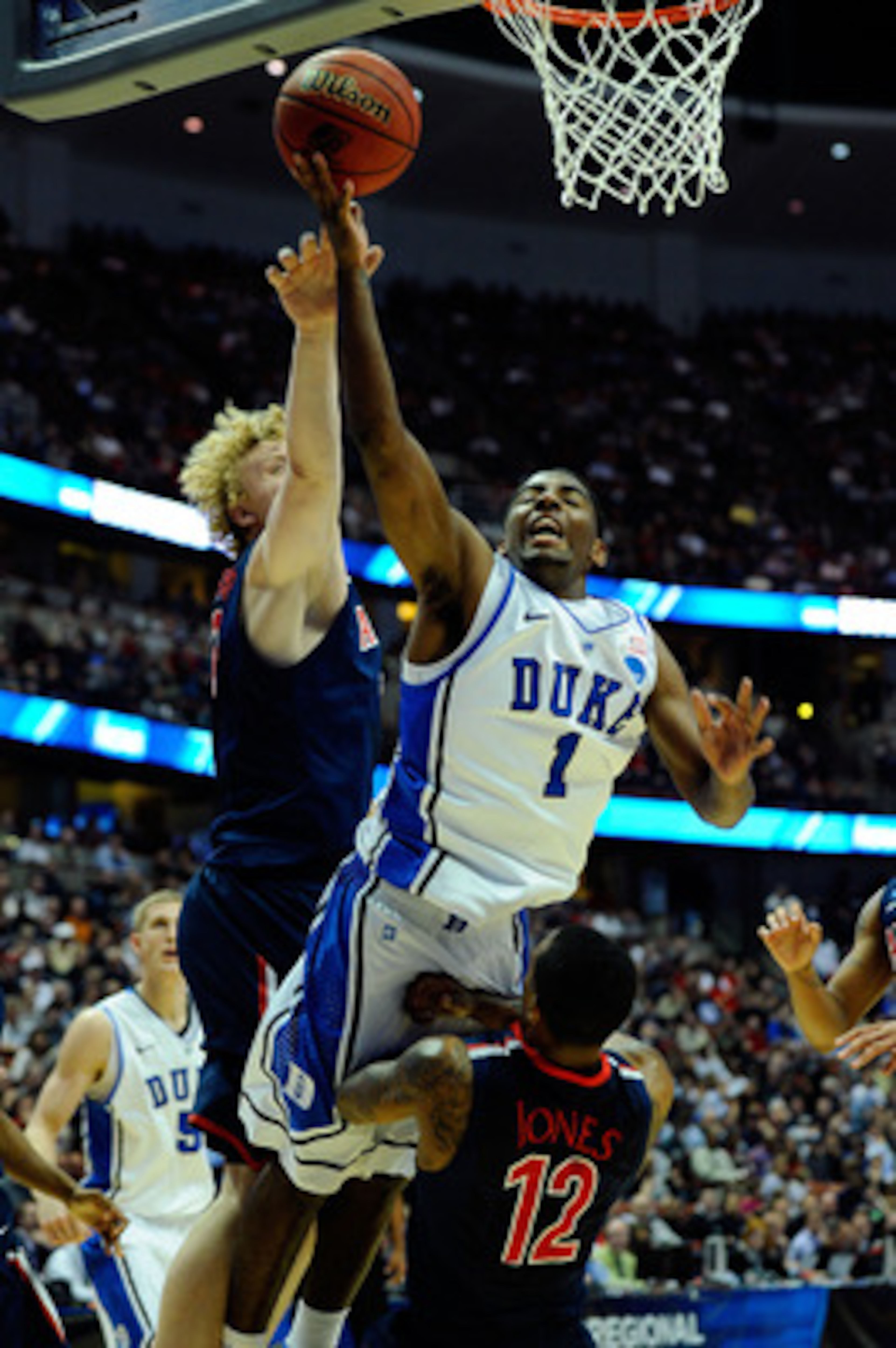ANAHEIM, CA - MARCH 24: Kyrie Irving #1 of the Duke Blue Devils draws contact against Kyryl Natyazhko #1 and Lamont Jones #12 of the Arizona Wildcats during the west regional semifinal of the 2011 NCAA men's basketball tournament at the Honda Center on M ANAHEIM, CA - MARCH 24: Kyrie Irving #1 of the Duke Blue Devils draws contact against Kyryl Natyazhko #1 and Lamont Jones #12 of the Arizona Wildcats during the west regional semifinal of the 2011 NCAA men's basketball tournament at the Honda Center on M