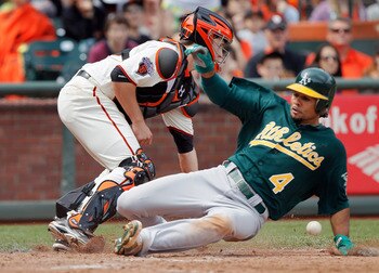 SAN FRANCISCO, CA - MAY 22:  Coco Crisp #4 of the Oakland A's scores a go-ahead run from second base ahead of the throw to catcher Buster Posey #28 of the San Francisco Giants on a single by Daric Barton in the seventh inning at AT&T Park on May 22, 2011 