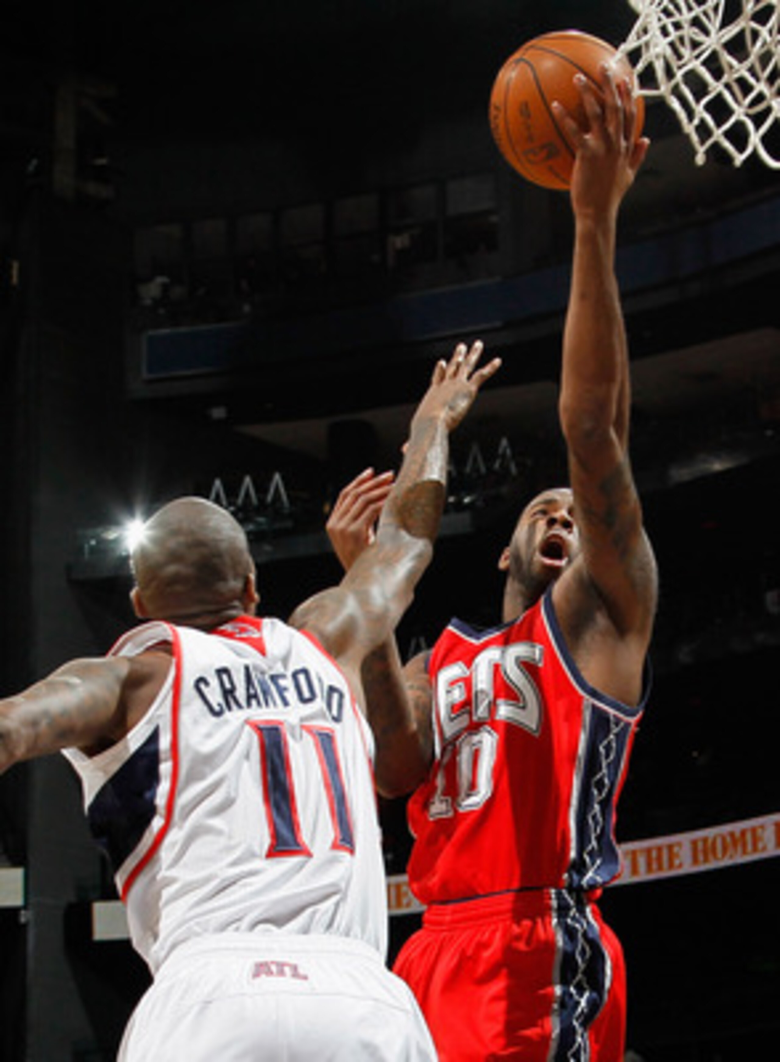 ATLANTA, GA - DECEMBER 07:  Damion James #10  of the New Jersey Nets drives the basket against Jamal Crawford #11 of the Atlanta Hawks at Philips Arena on December 7, 2010 in Atlanta, Georgia.  NOTE TO USER: User expressly acknowledges and agrees that, by