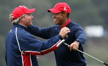 SAN FRANCISCO - OCTOBER 11:  Fred Couples the Captain of the USA Team races to congratulate Tiger Woods after he had holed the winning putt at the 13th hole where he beat his opponent Y.E.Yang 6&5 during the Day Four Singles Matches in The Presidents Cup