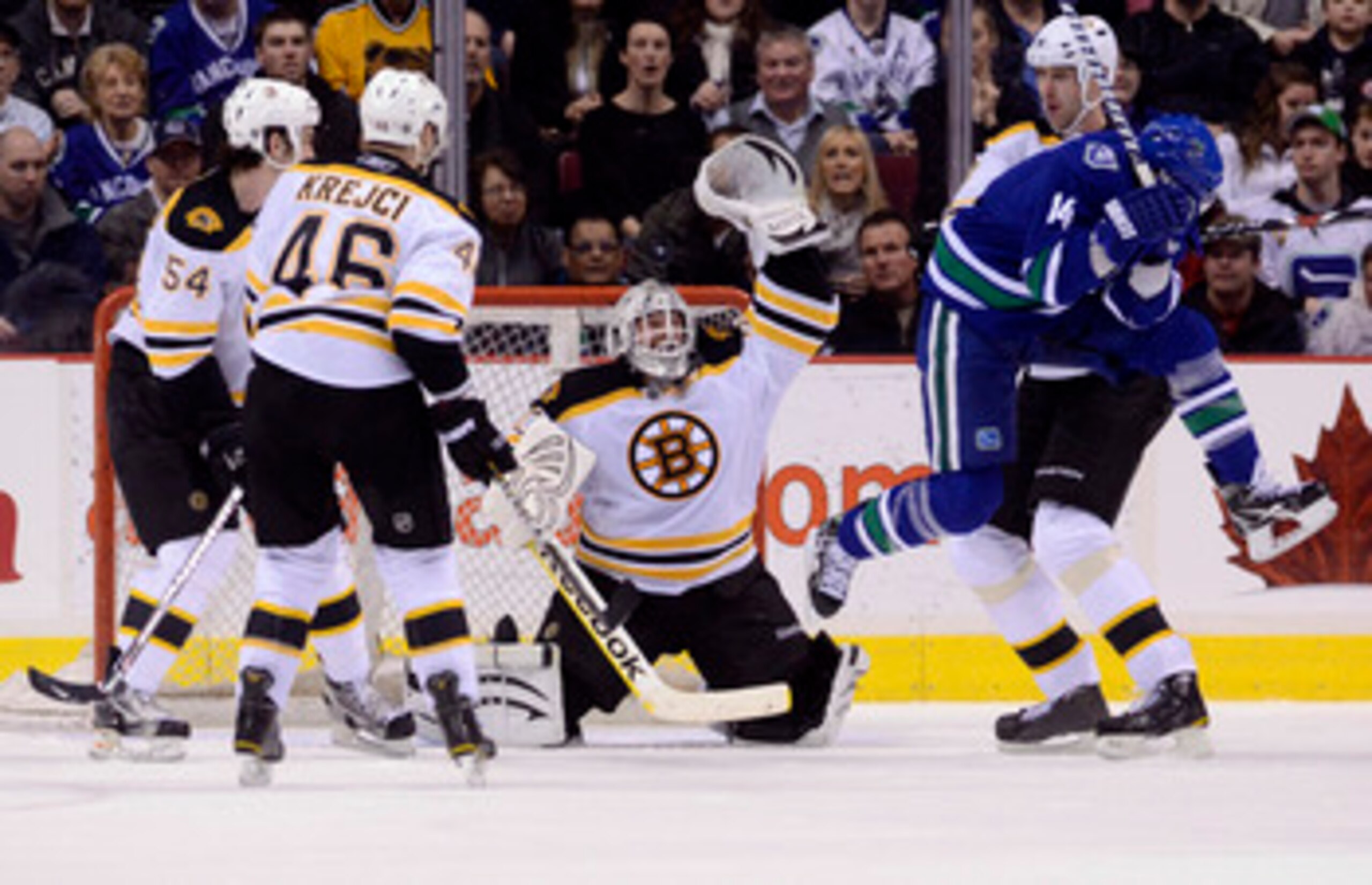 VANCOUVER, CANADA - FEBRUARY 26: Alexandre Burrows #14 of the Vancouver Canucks jumps out of the way of a shot as the puck sails over the head of goalie Tim Thomas #30 of the Boston Bruins during the third period in NHL action on February 26, 2011 at Roge