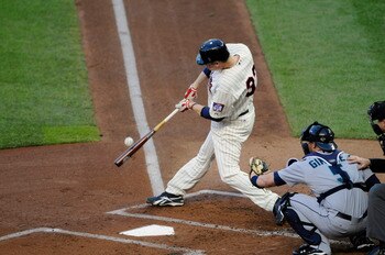 MINNEAPOLIS, MN - MAY 23: Justin Morneau #33 of the Minnesota Twins bats while catcher Chris Gimenez #5 of the Seattle Mariners defends home plate during their game on May 23, 2011 at Target Field in Minneapolis, Minnesota. The Rockies won 6-5. (Photo by