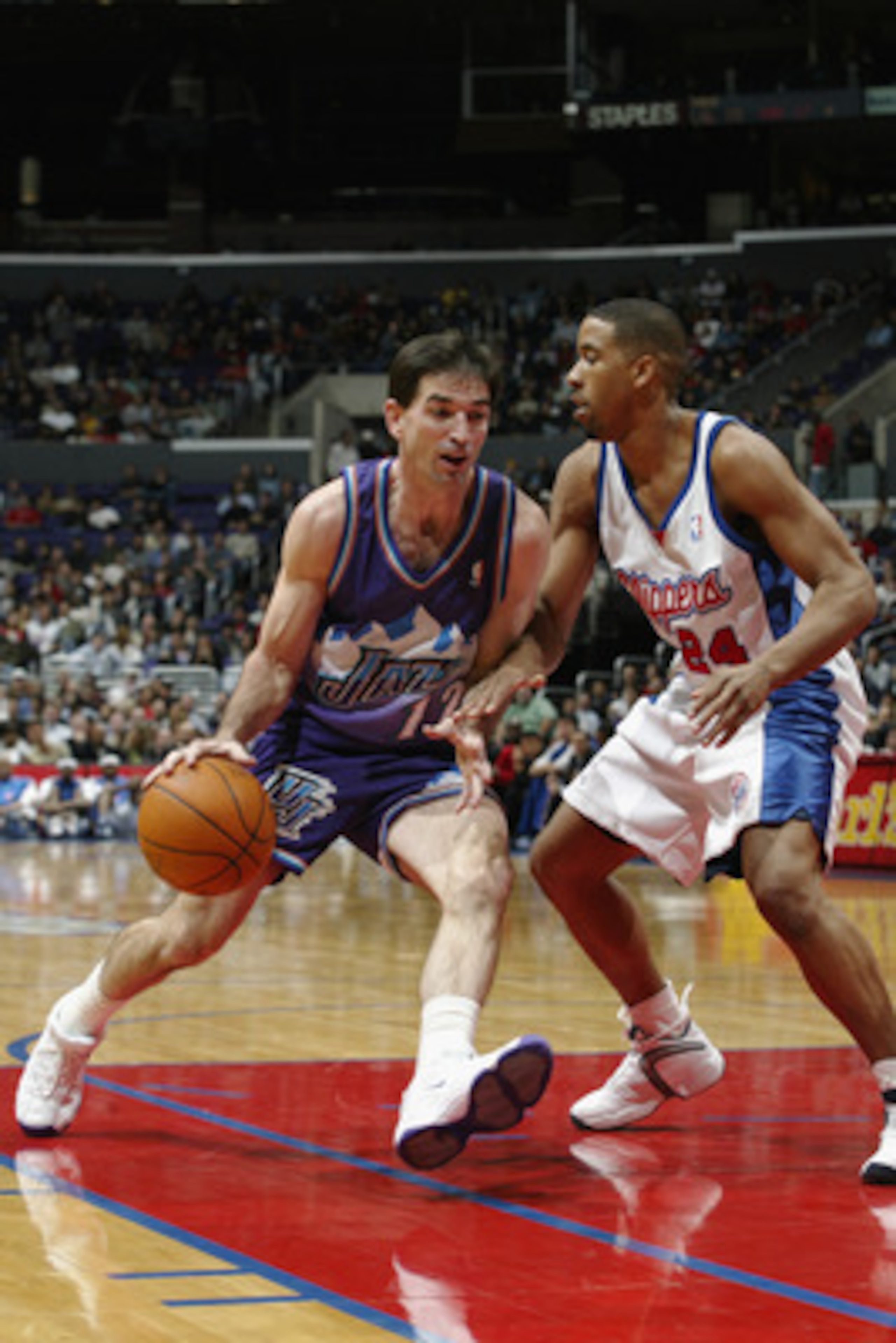 LOS ANGELES - NOVEMBER 26:  John Stockton #12 of the Utah Jazz drives against Andre Miller #24 of the Los Angeles Clippers during the game at Staples Center on November 26, 2002 in Los Angeles, California.  The Jazz won 99-94.  NOTE TO USER: User expressl