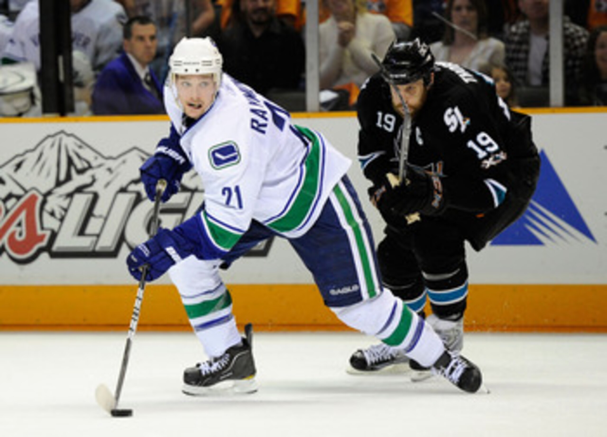 SAN JOSE, CA - MAY 20:  Mason Raymond #21 of the Vancouver Canucks plays the puck in the neutral zone under pressure from Joe Thornton #19 of the San Jose Sharks in Game Three of the Western Conference Finals during the 2011 Stanley Cup Playoffs at HP Pav