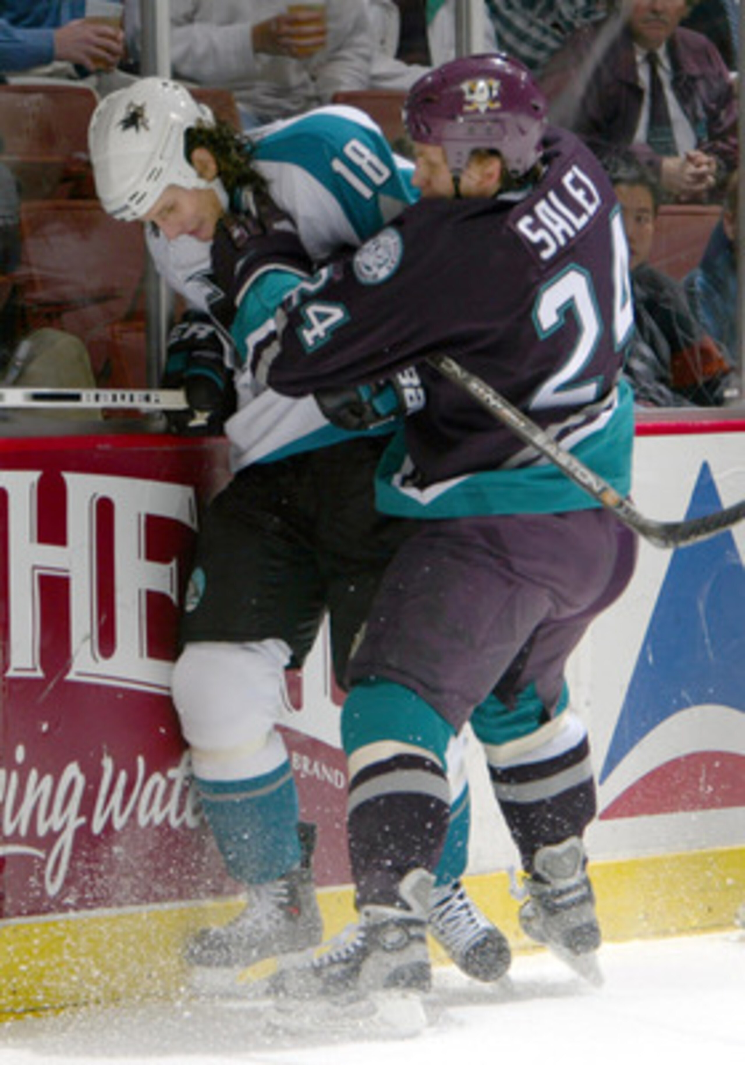 SAN DIEGO - DECEMBER 10: Mike Ricci #19 of the San Jose Sharks is checked by Ruslan Salei #24 of the Anaheim Mighty Ducks during the 2nd period of their NHL game on December 10, 2003 at the Arrowhead Pond in Anaheim, California. (Photo by Donald Miralle SAN DIEGO - DECEMBER 10: Mike Ricci #19 of the San Jose Sharks is checked by Ruslan Salei #24 of the Anaheim Mighty Ducks during the 2nd period of their NHL game on December 10, 2003 at the Arrowhead Pond in Anaheim, California. (Photo by Donald Miralle