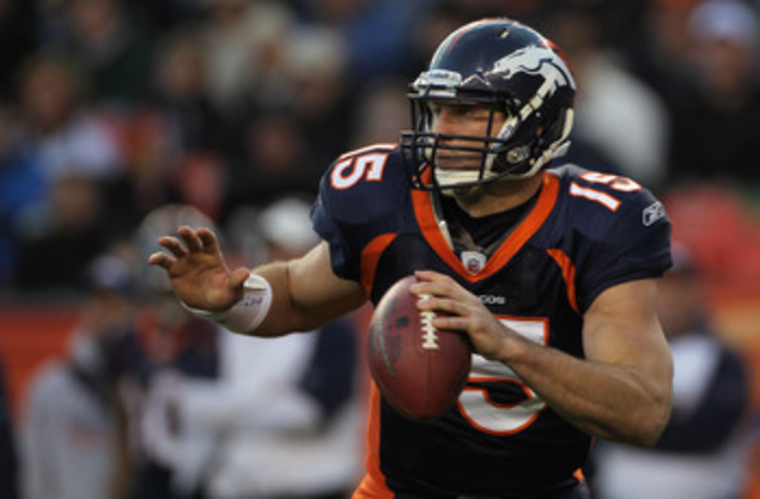 DENVER - DECEMBER 26:  Quarterback Tim Tebow #15 of the Denver Broncos rolls out and looks to deliver a pass against the Houston Texas at INVESCO Field at Mile High on December 26, 2010 in Denver, Colorado. The Broncos defeated the Texans 24-23.  (Photo b